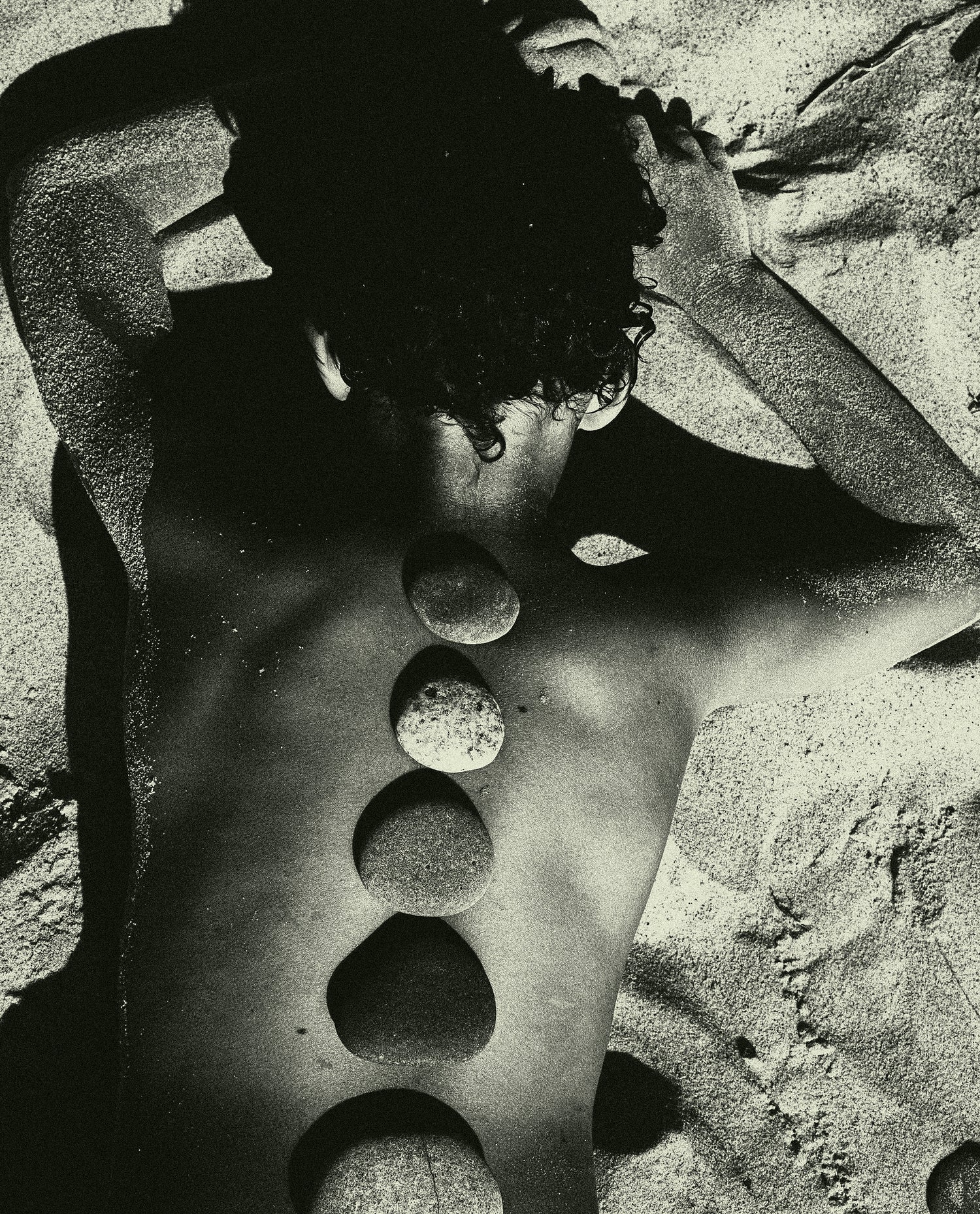 Baltic Stones by Jonė Reed, arrangement of smooth rounded stones placed along a person’s back in a pattern.
