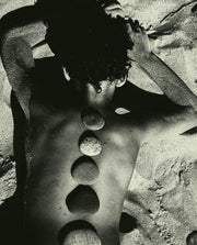Baltic Stones by Jonė Reed, arrangement of smooth rounded stones placed along a person’s back in a pattern.