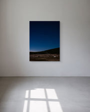 Framed and ready-to-hang photograph of a landscape with a blue sky on a white wall.