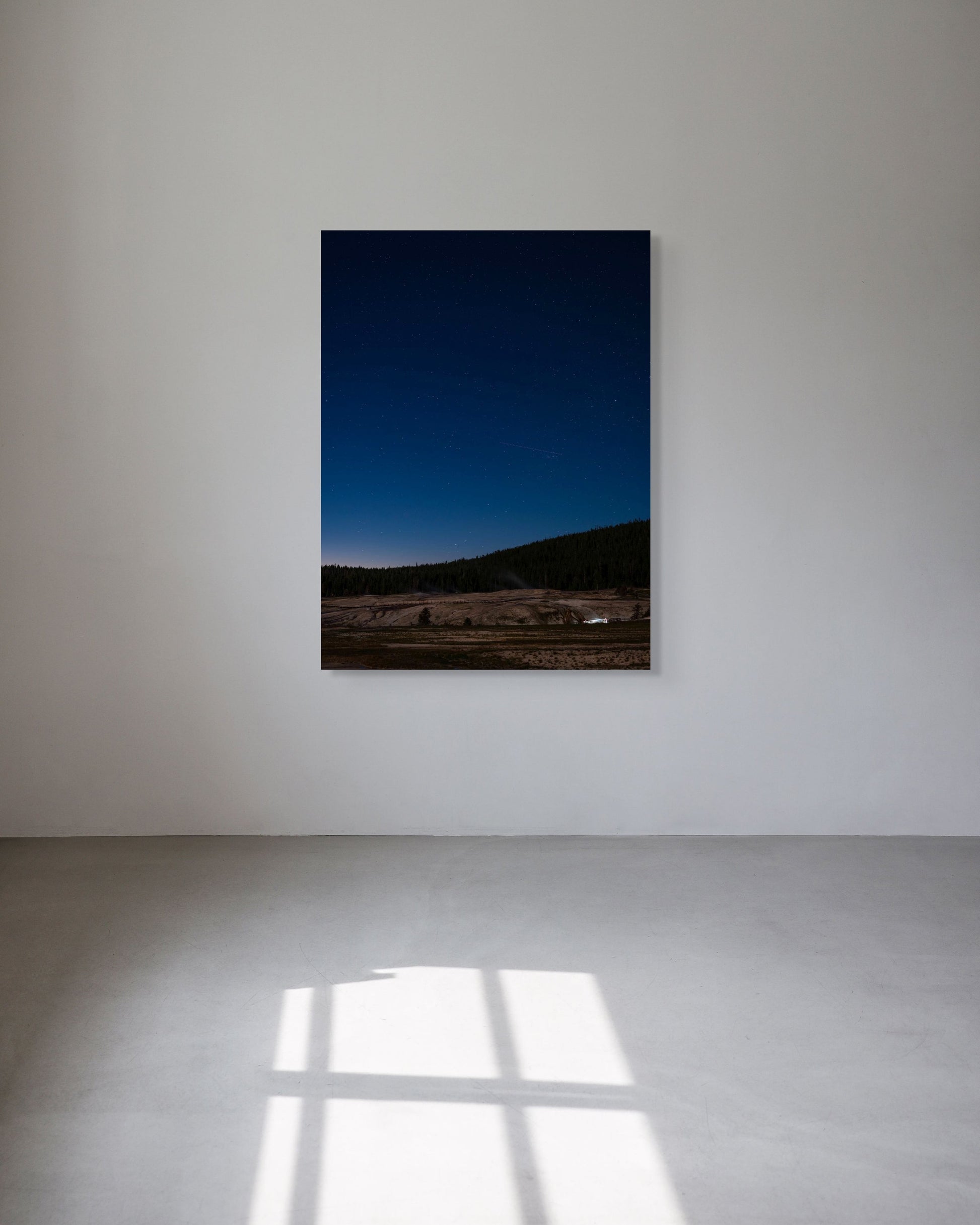 Framed and ready-to-hang photograph of a landscape with a blue sky on a white wall.