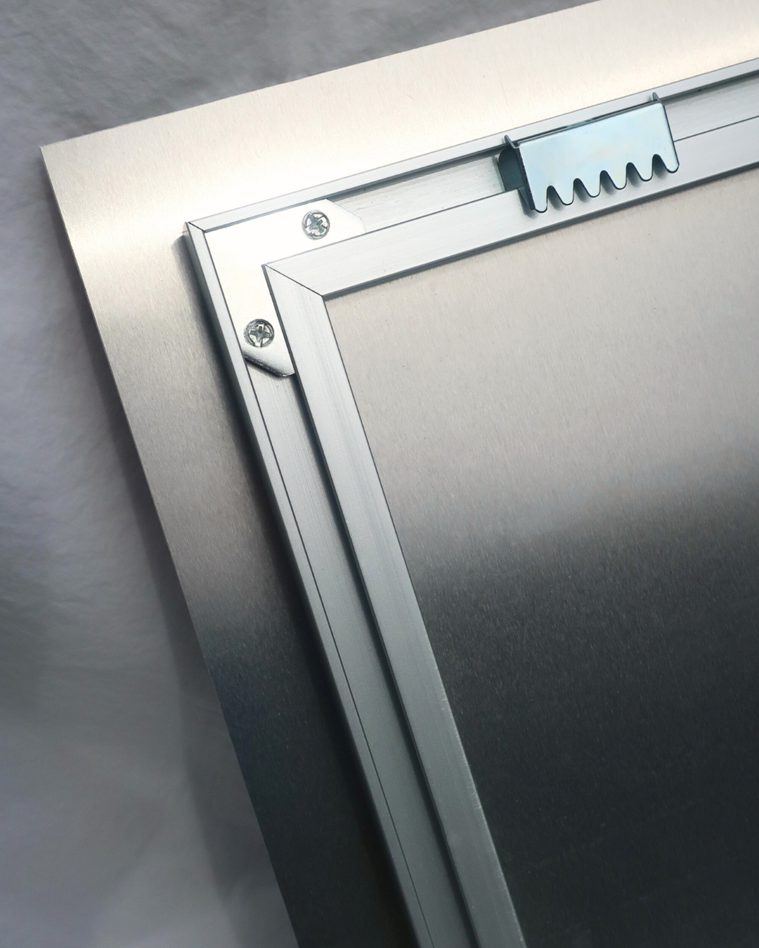 Metallic frame with a textured corner detail on a gray background