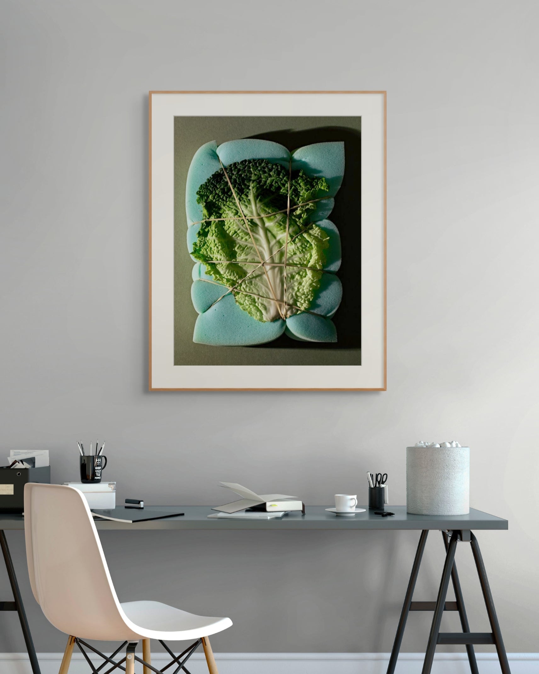 Wood-framed photograph with a white mat hanging above a modern desk.