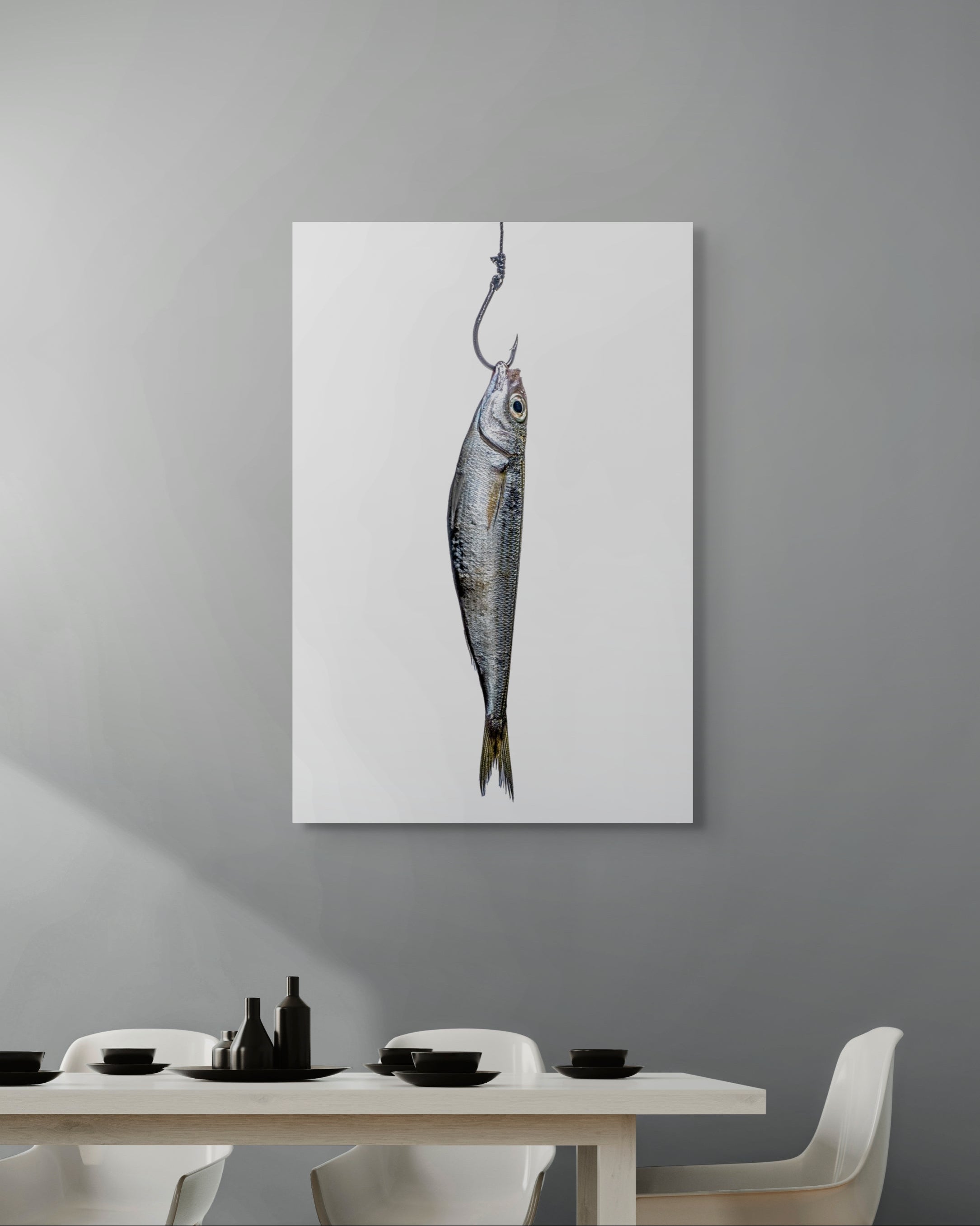 Framed artwork of a fish on a hook hanging on a gray wall above a dining table.