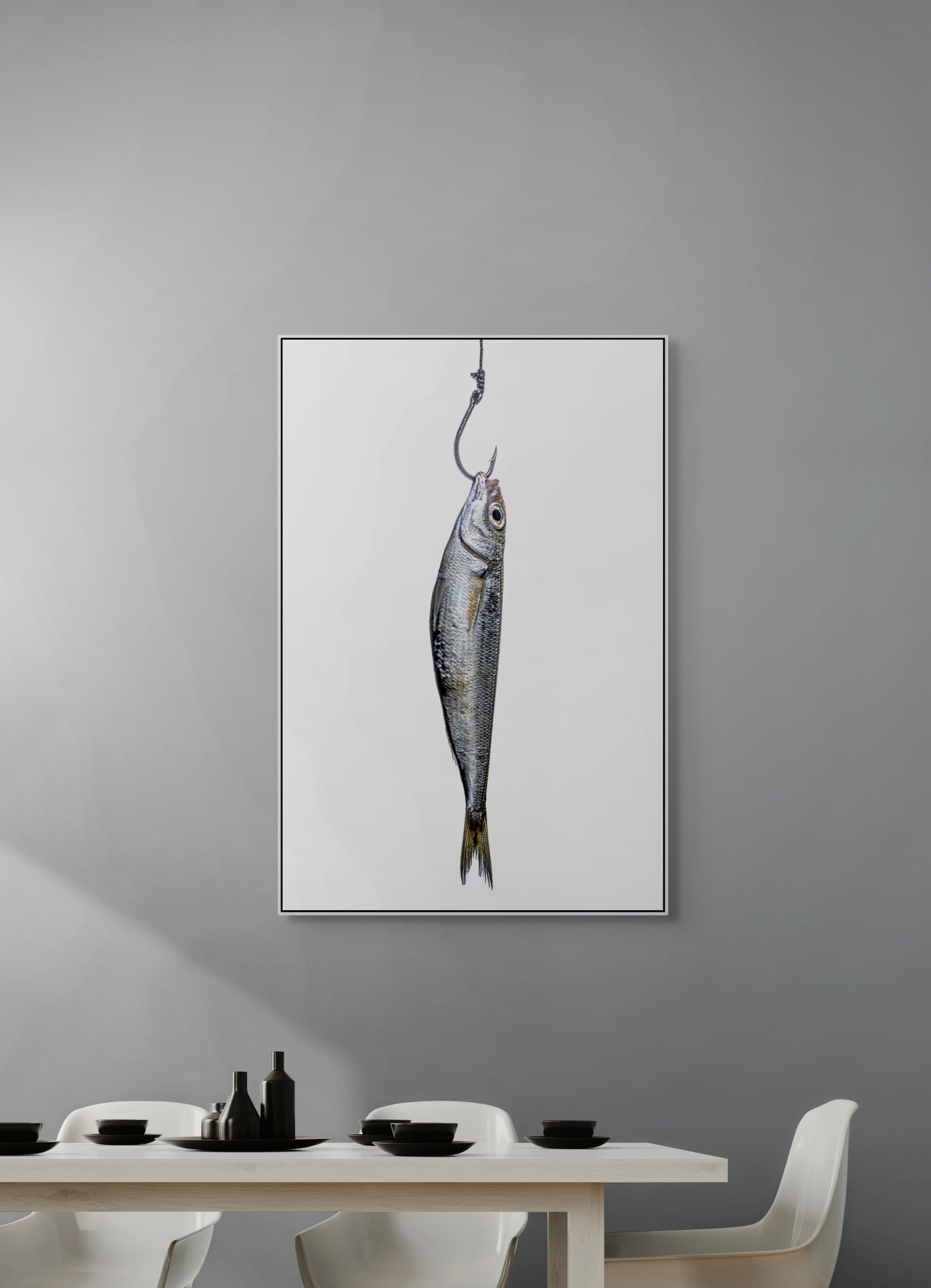 Framed artwork of a fish on a hook hanging on a gray wall above a dining table.
