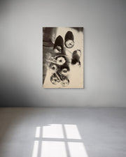 Framed artwork of a black and white abstract design on a gray wall.