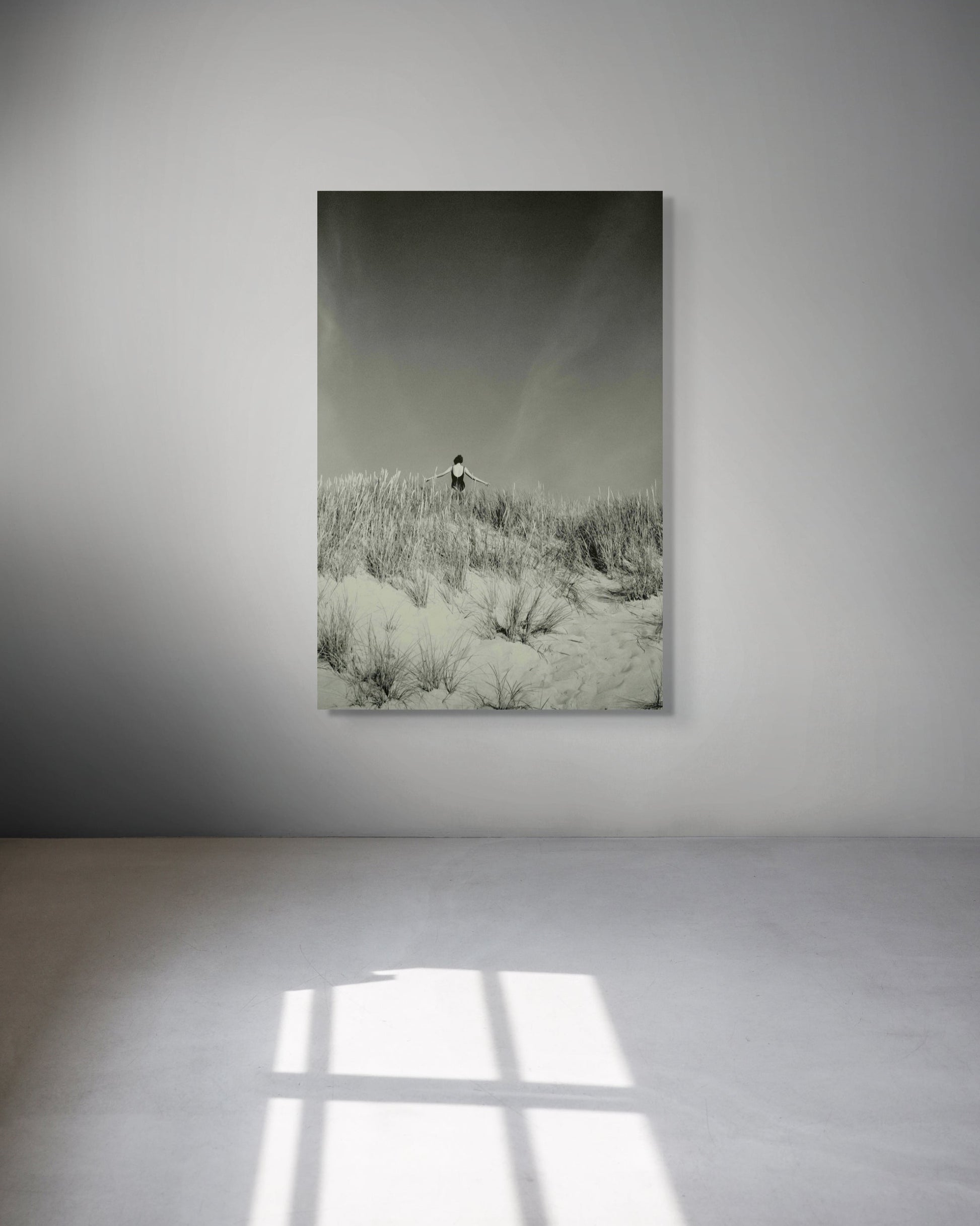 Framed photograph of a person standing on a snowy landscape in a minimalistic room.