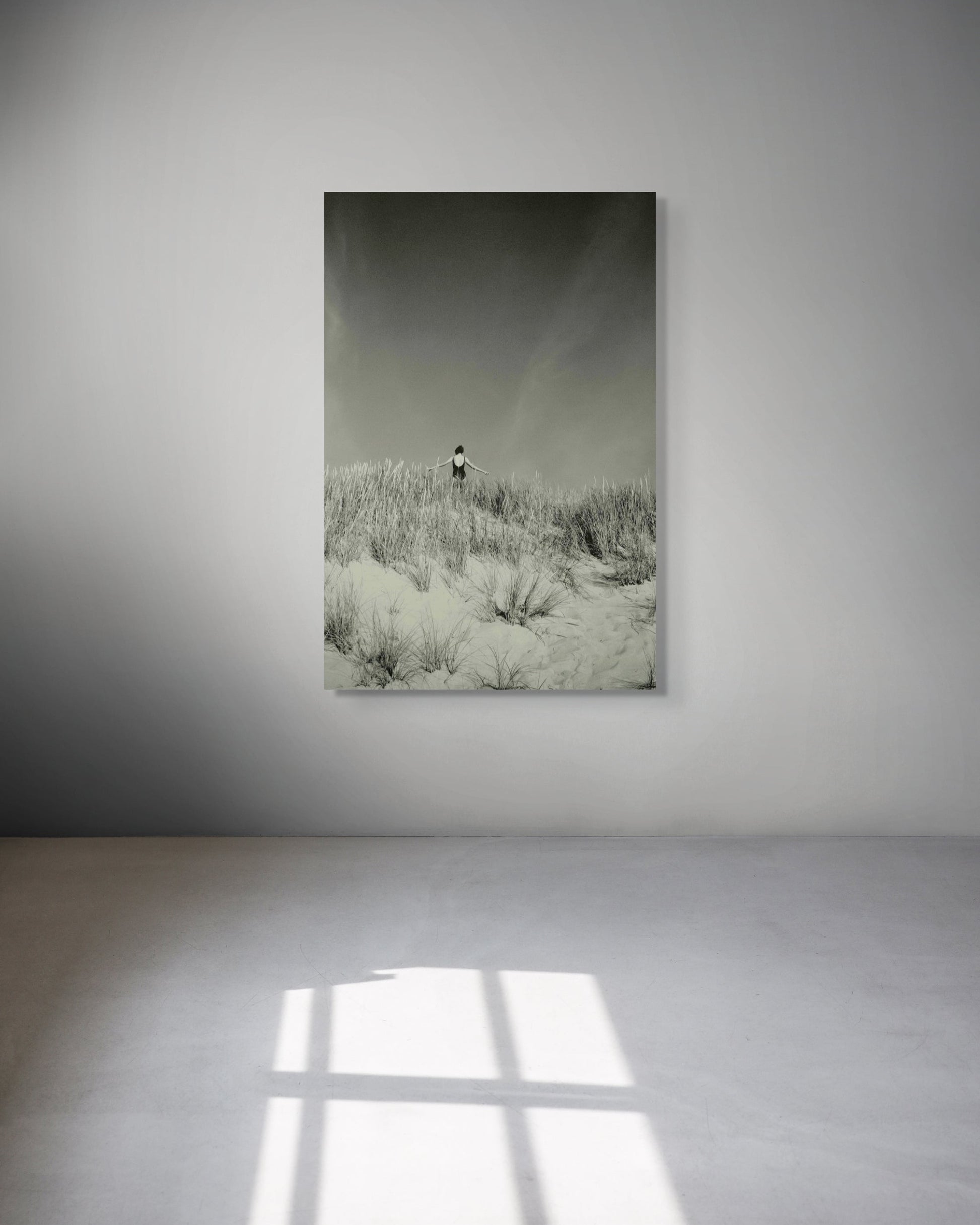 Framed photograph of a person in the dune on a white wall