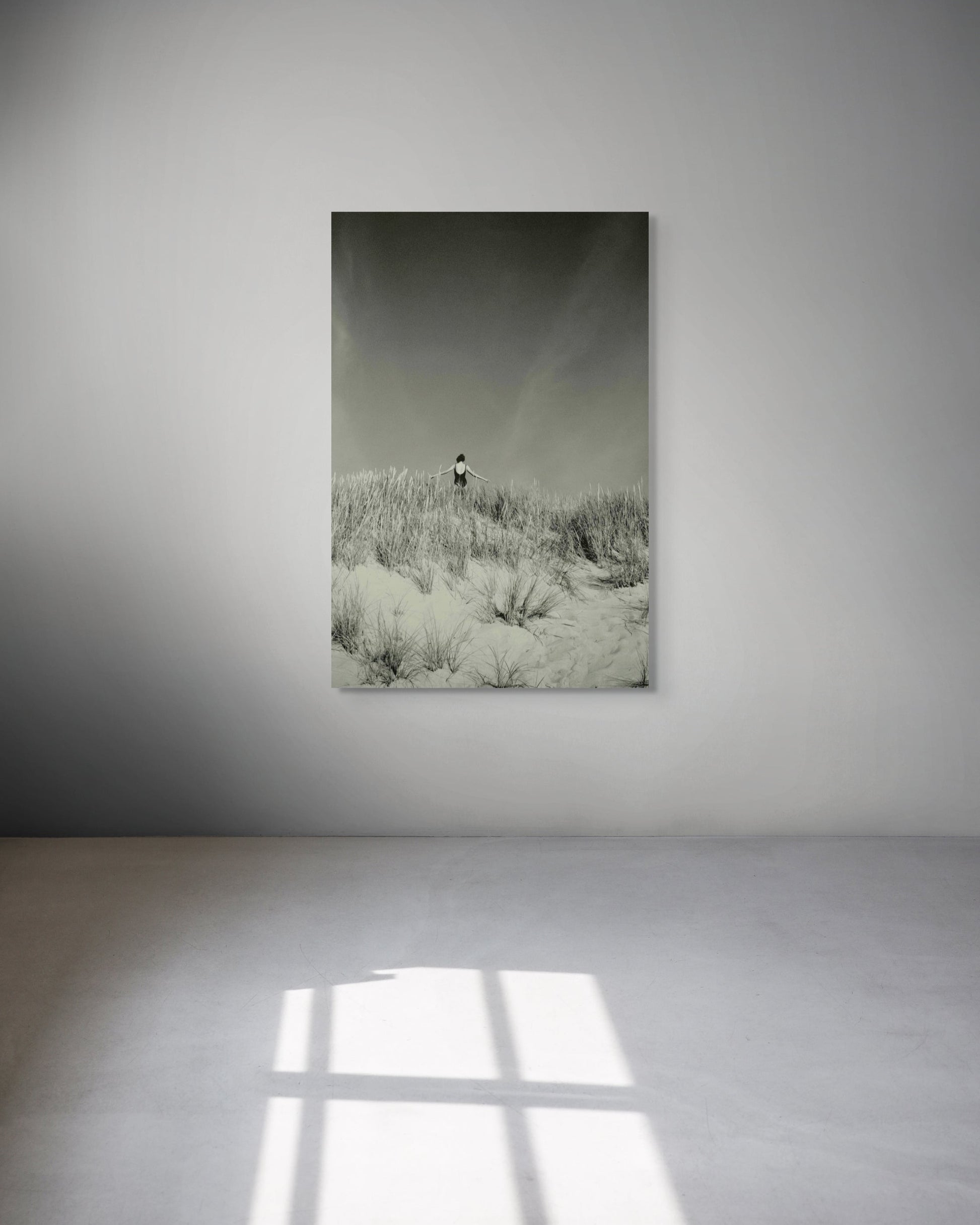 Metal print of a landscape with a rainbow hanging on a white wall.