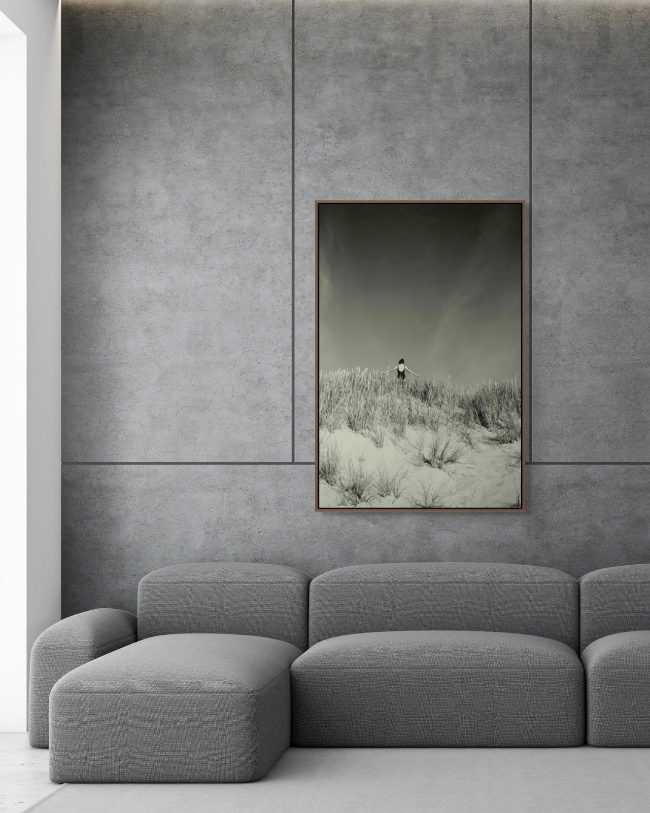 Gray sectional sofa in a room with a textured wall and framed artwork.