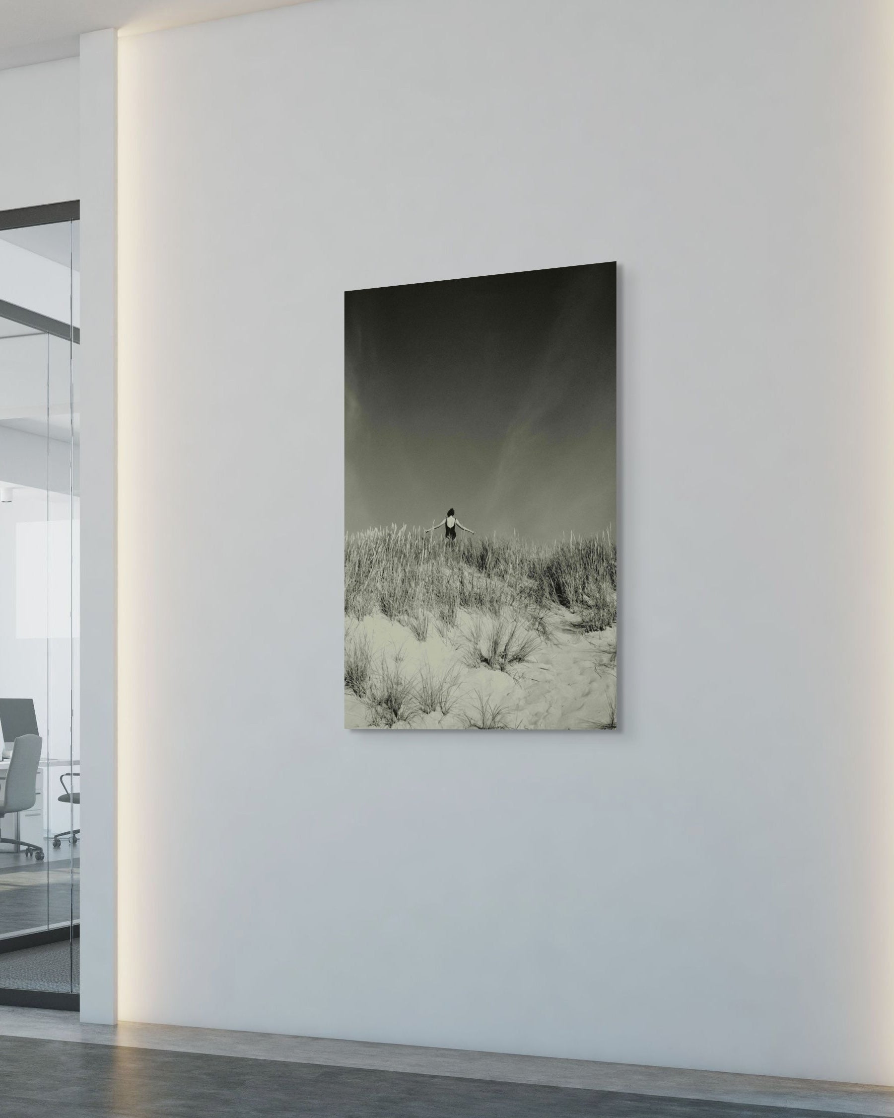 Modern office interior with a large wall art piece depicting a dune landscape.