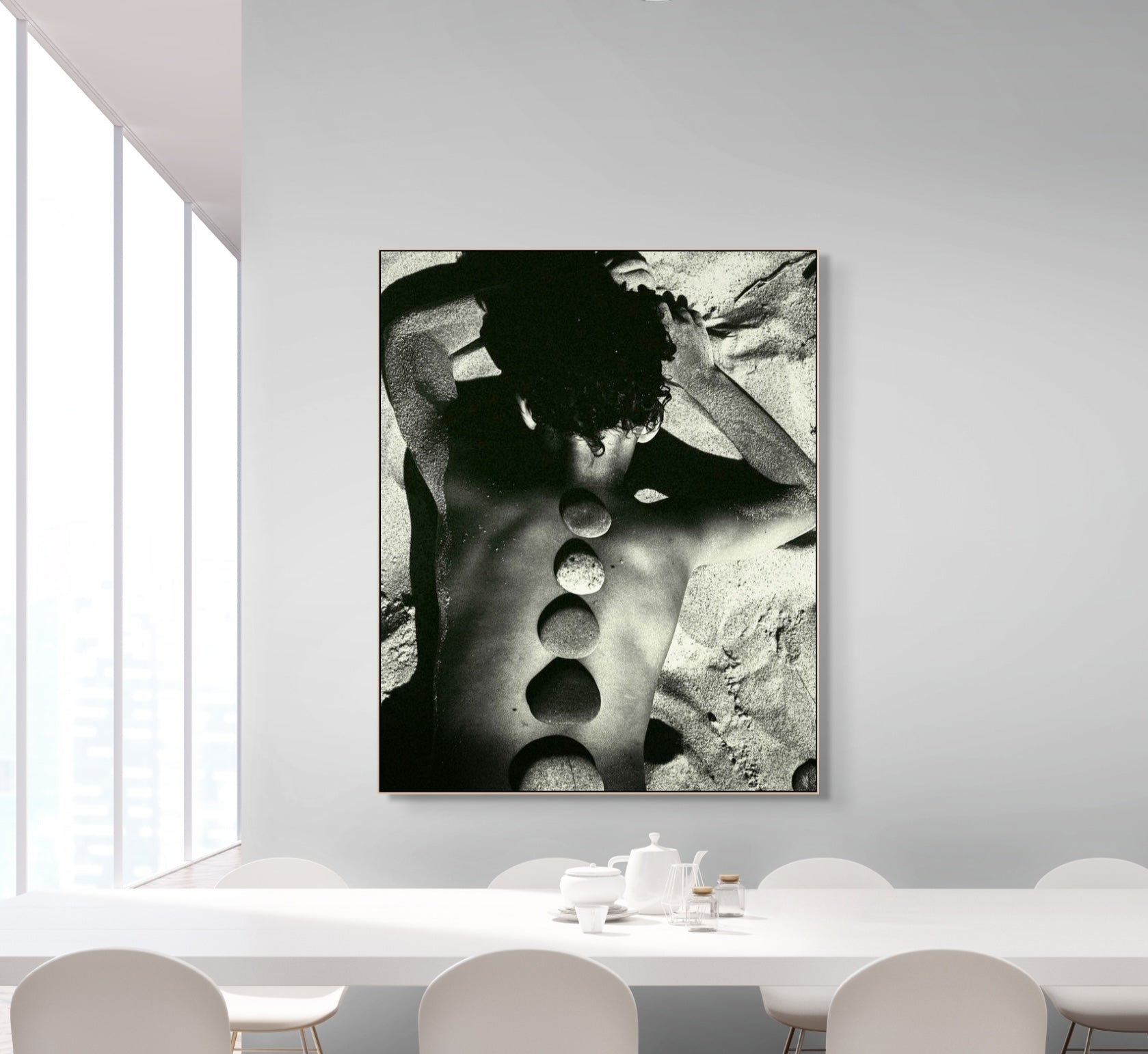 Black and white abstract art piece on a wall above a dining table.