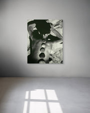 Abstract black and white artwork on a gray wall