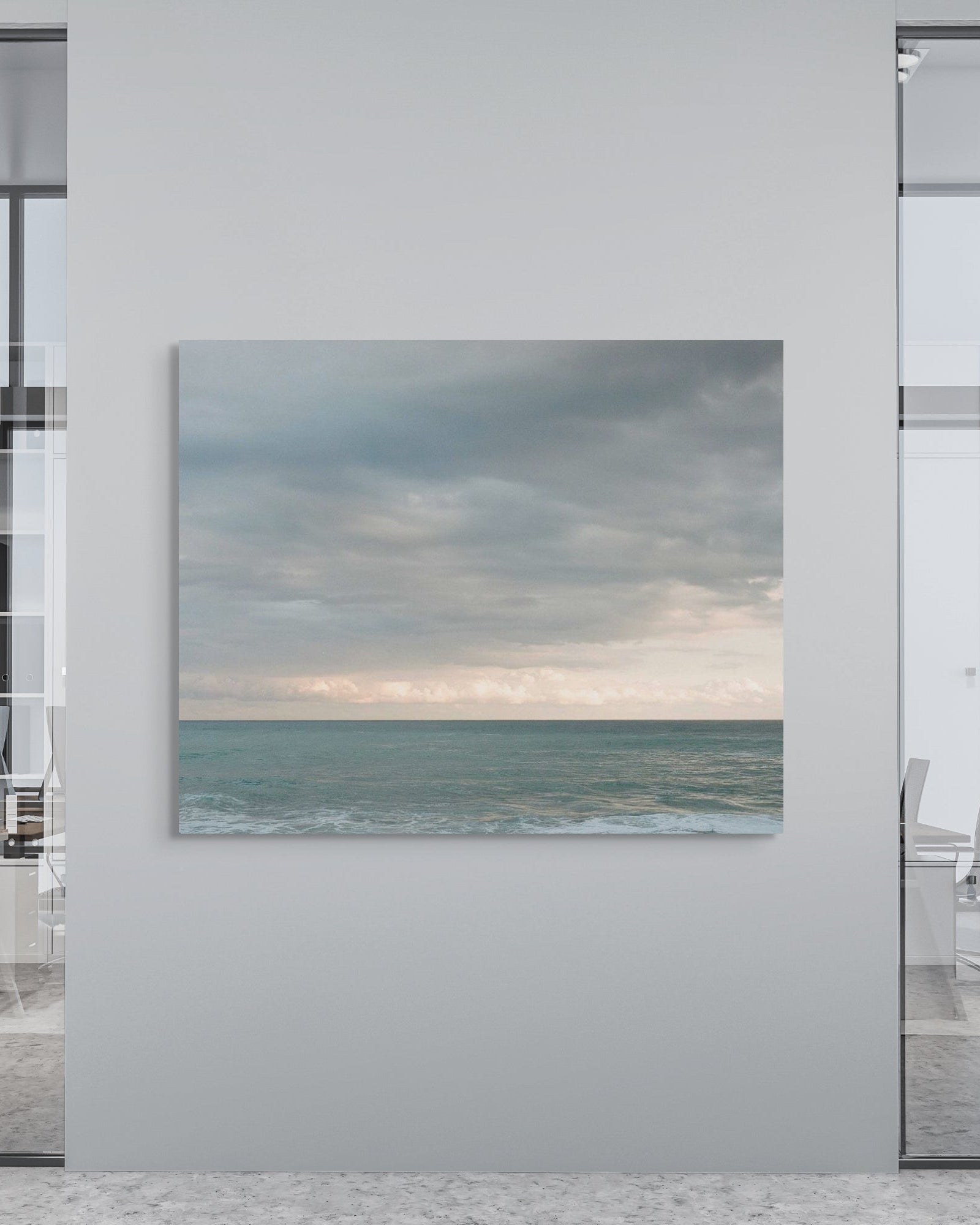 Modern office interior with a large metal print of a beach scene on a wall.