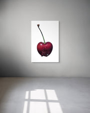 Framed artwork of a red cherry on a white background