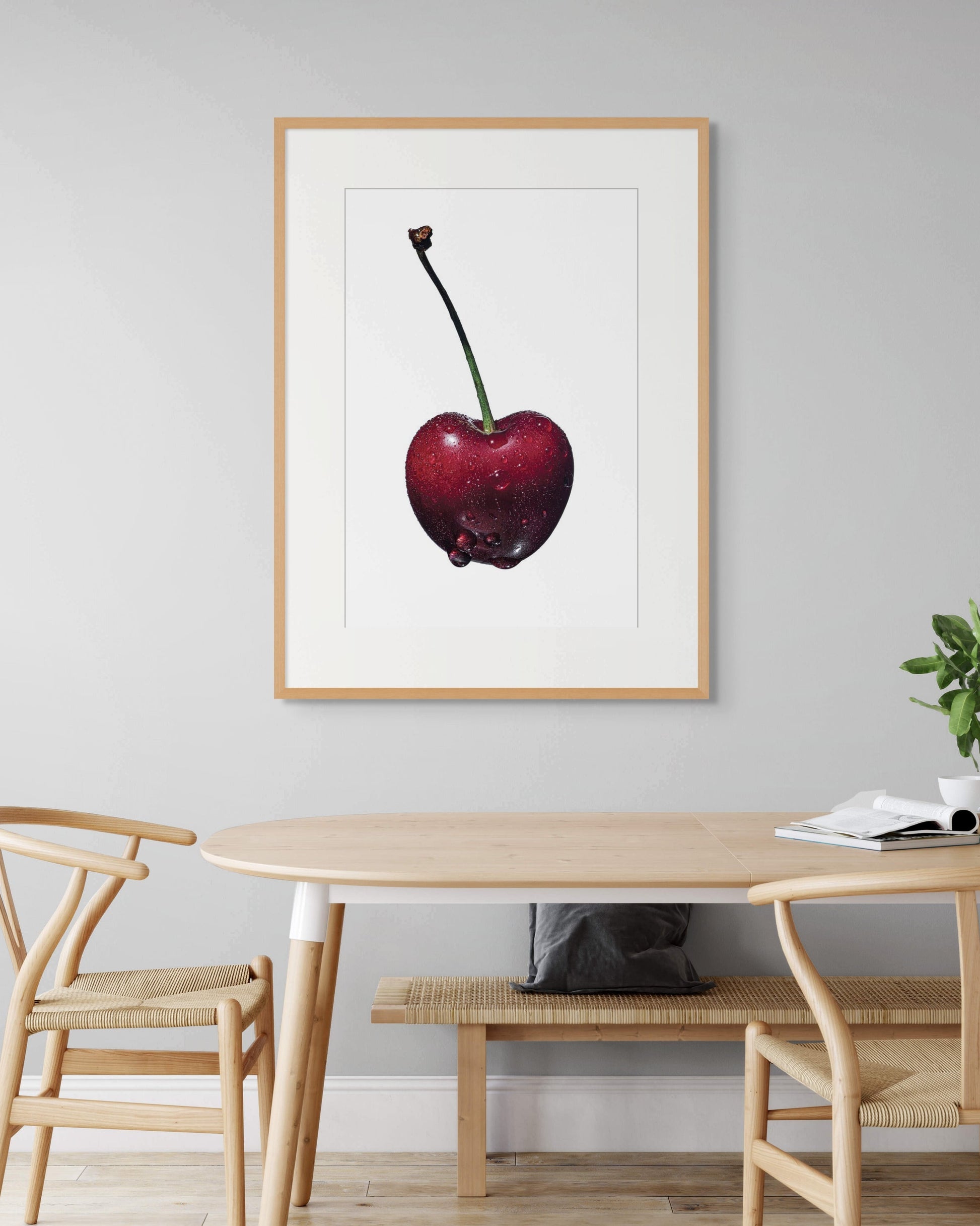 Black Cherry by Sivan Roshianu, a limited edition fine art print of a cherry on a wall above a dining table with chairs, archival.