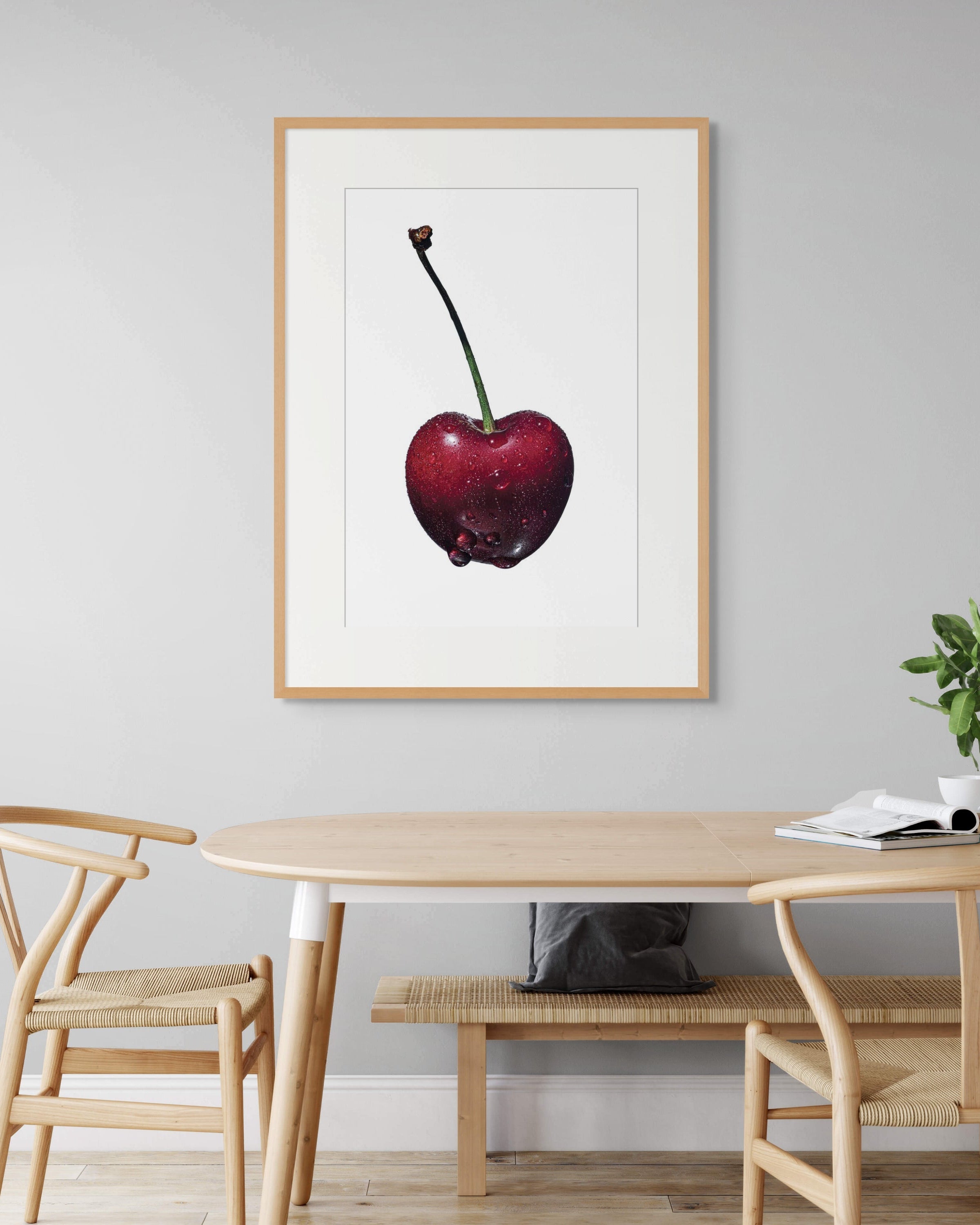 Black Cherry by Sivan Roshianu, a limited edition fine art print of a cherry on a wall above a dining table with chairs, archival.