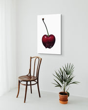 Black Cherry by Sivan Roshianu, a framed fine art print, a ready to hang metal print on a white wall with a wooden chair and plant below.