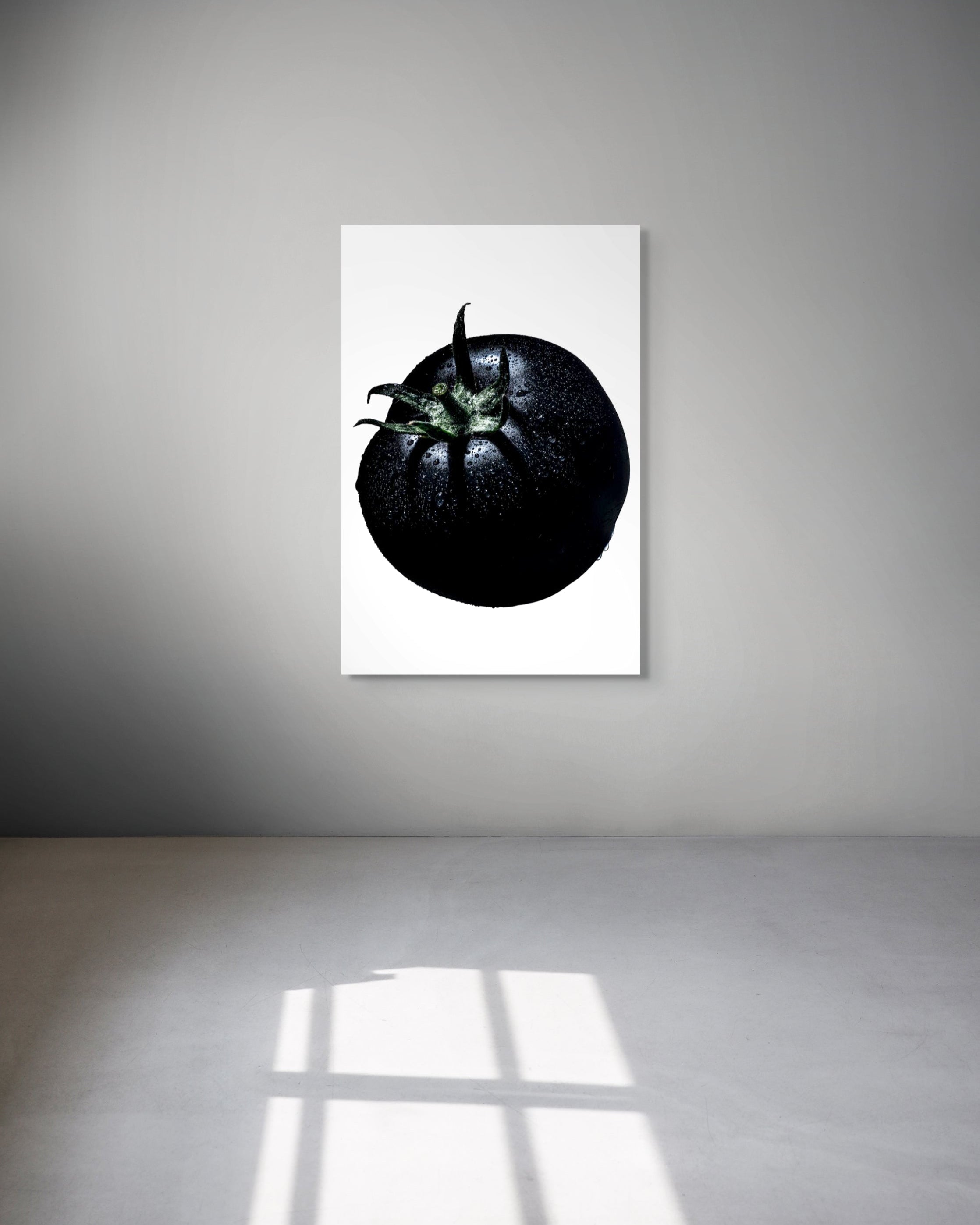 Framed artwork of a black tomato on a white background
