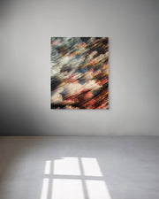 Abstract metal print on a gray wall with sunlight casting shadows on the floor.