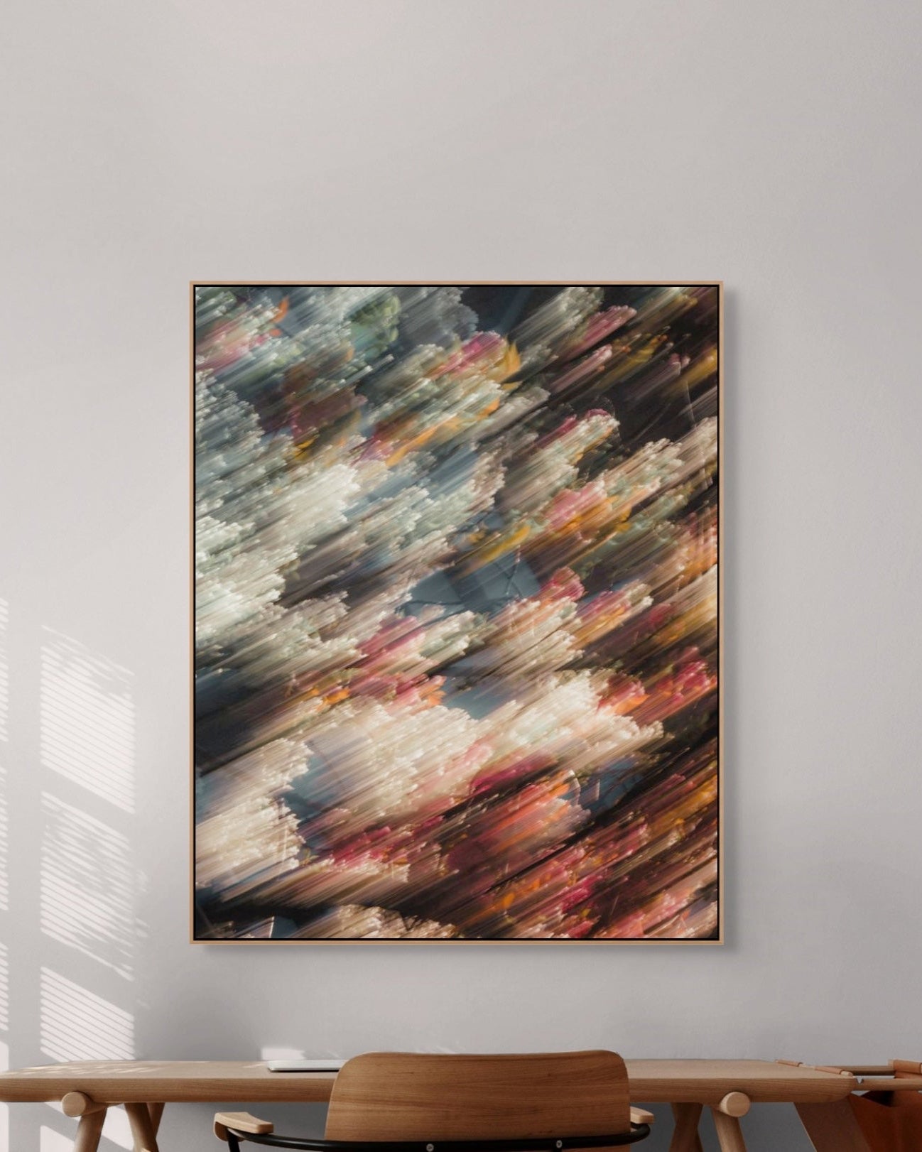 Abstract photograph on a gray wall above a wooden table