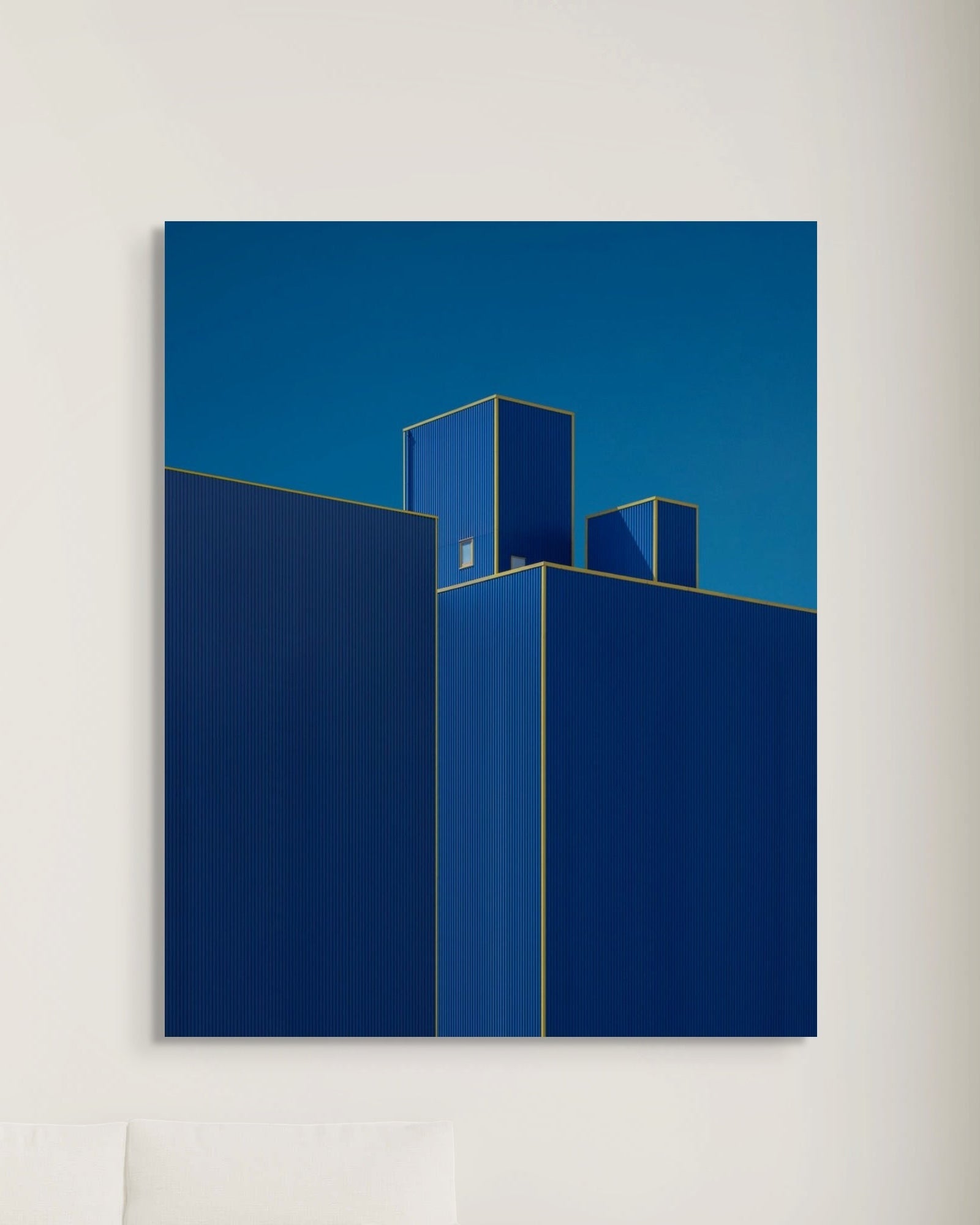 Abstract art print of blue geometric shapes on a white wall