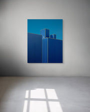 Abstract artwork with blue geometric shapes on a gray wall