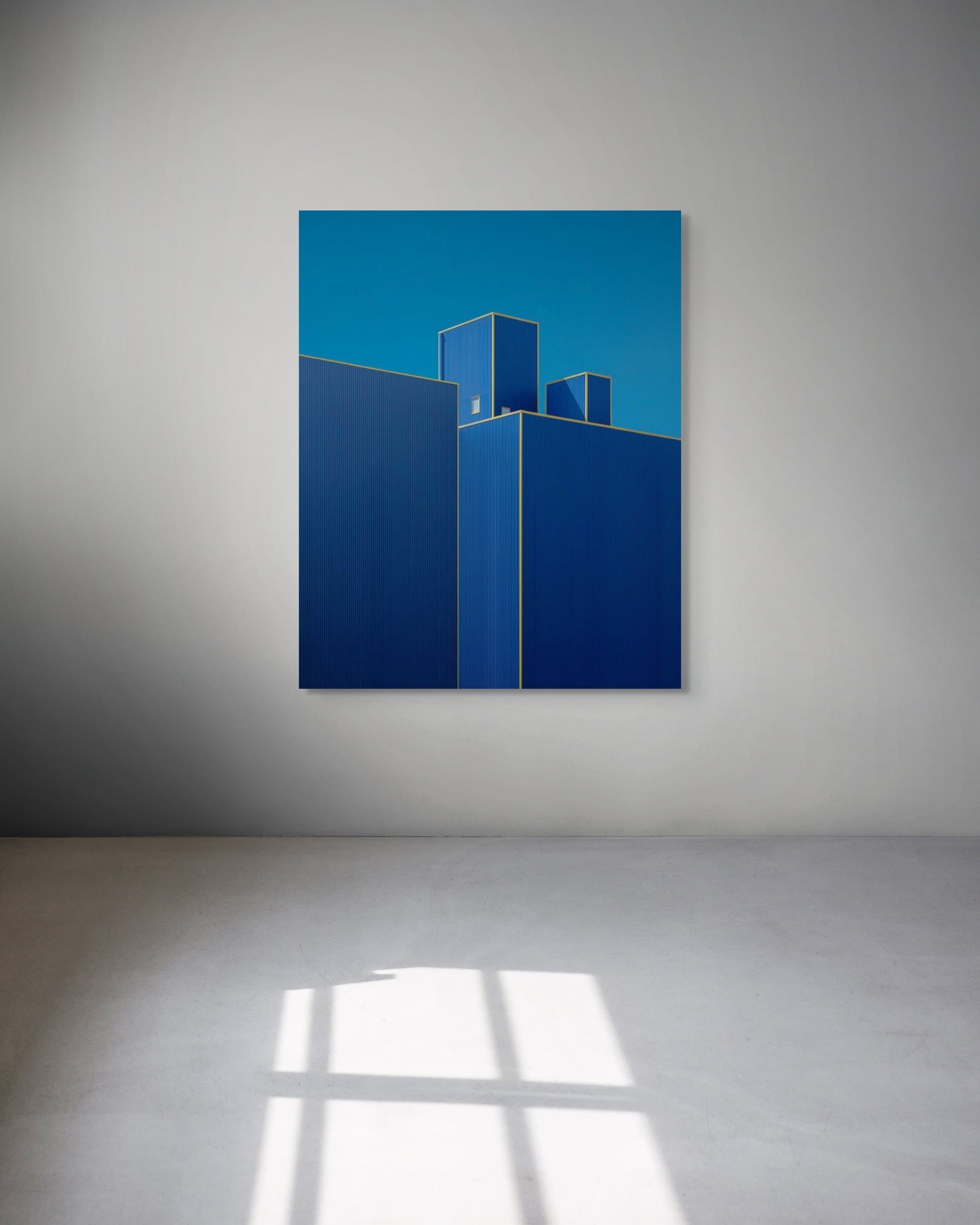Abstract artwork with blue geometric shapes on a gray wall
