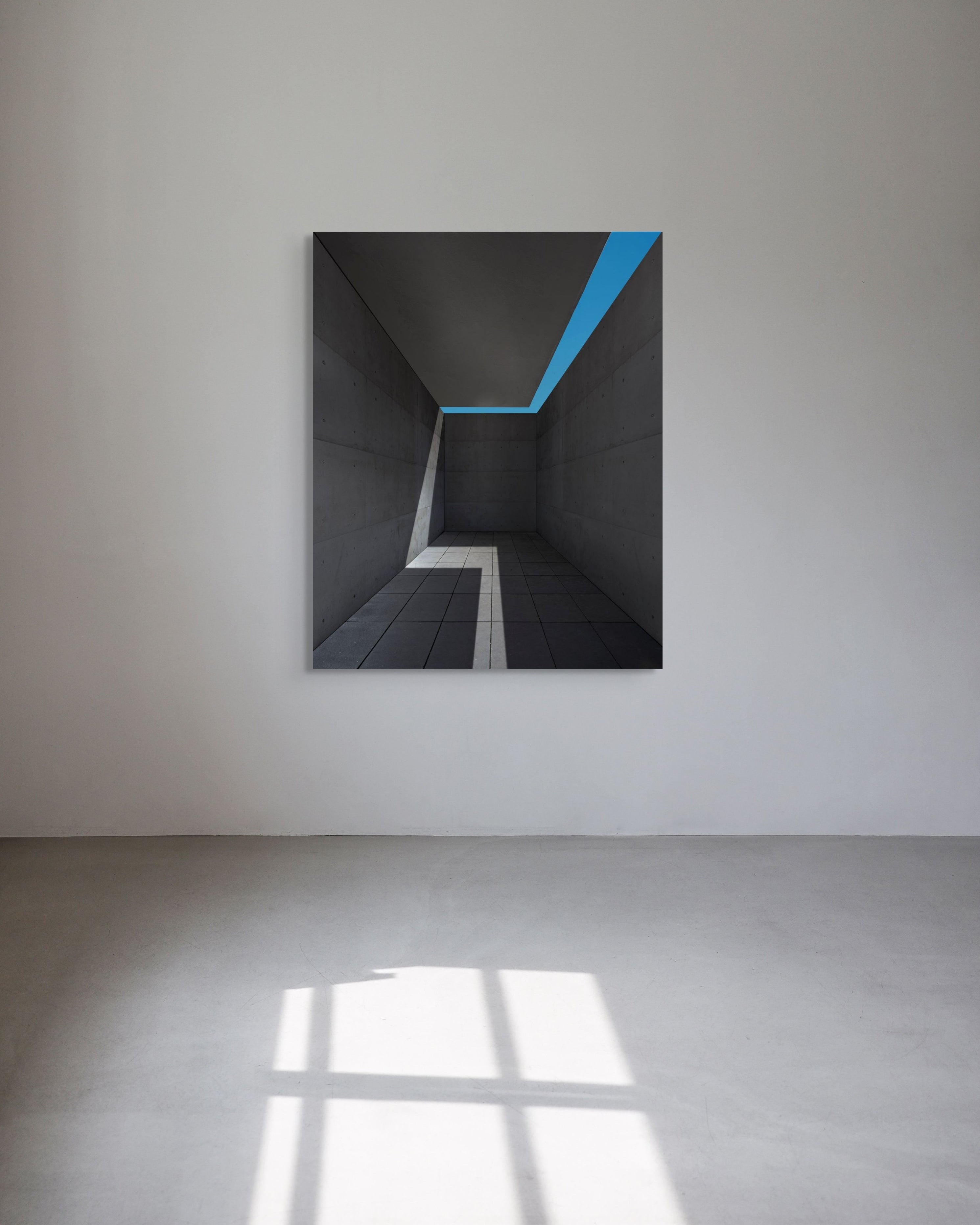 Abstract artwork with a blue diagonal line on a white wall