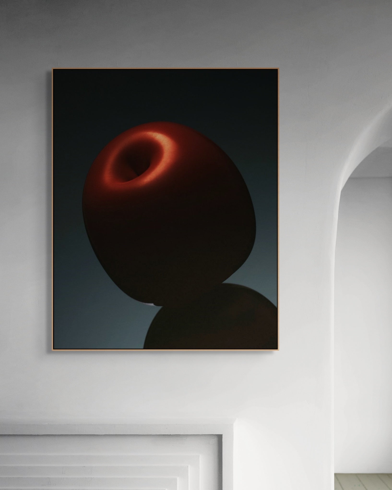Framed artwork of a red apple on a wall.