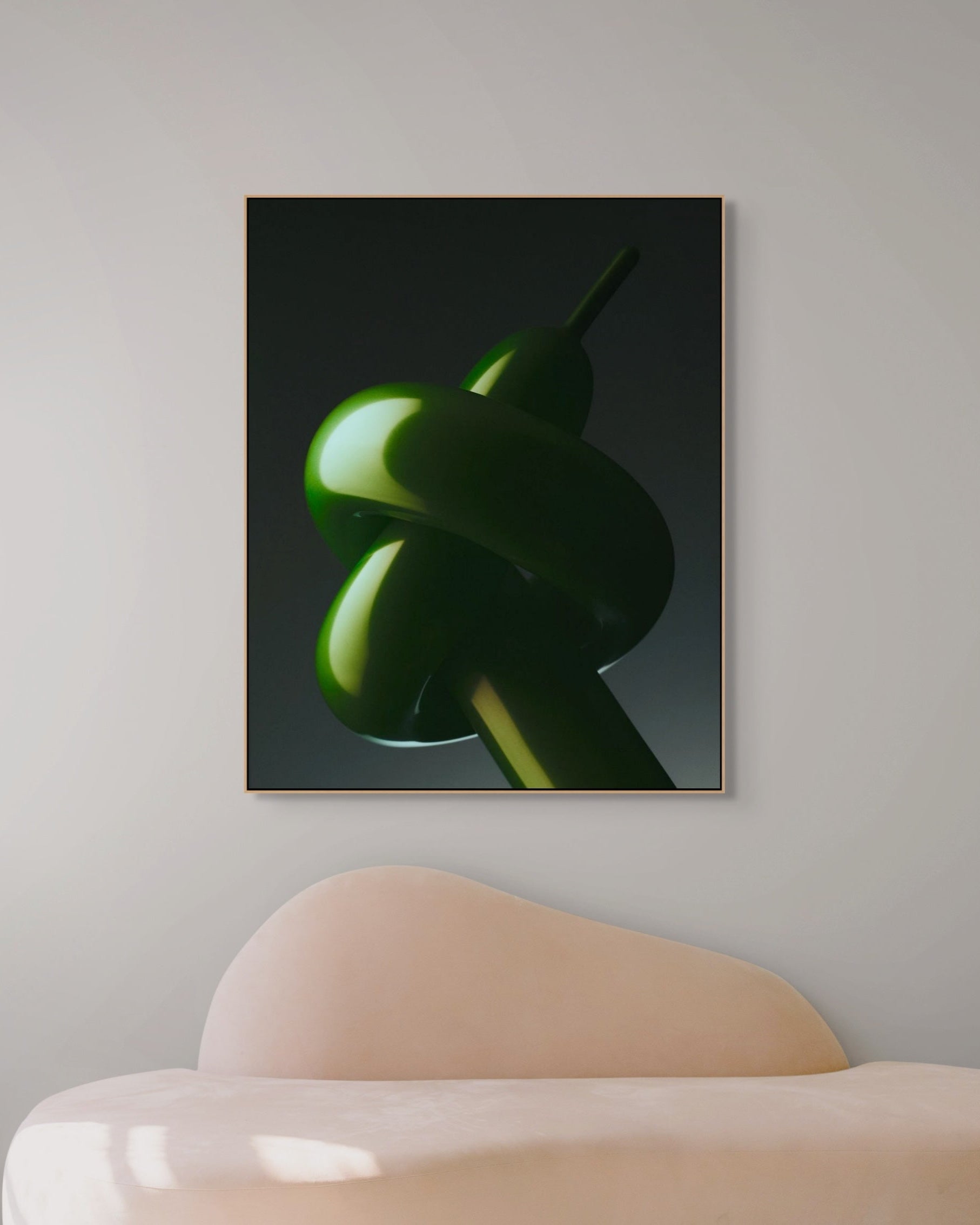Framed artwork of a green abstract shape on a gray wall above a modern chair.