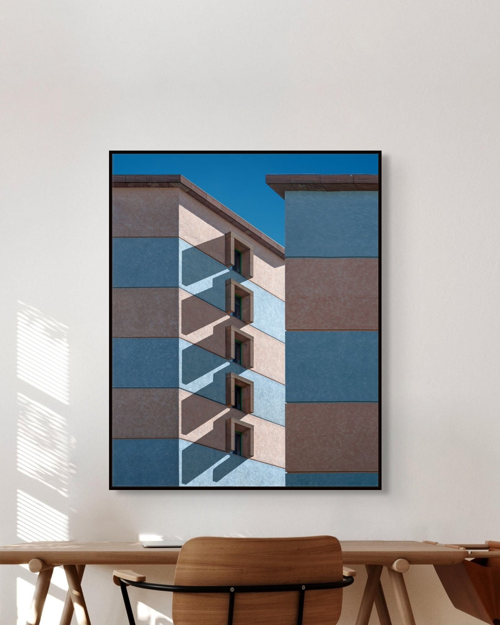 Architectural wall art above a wooden table.