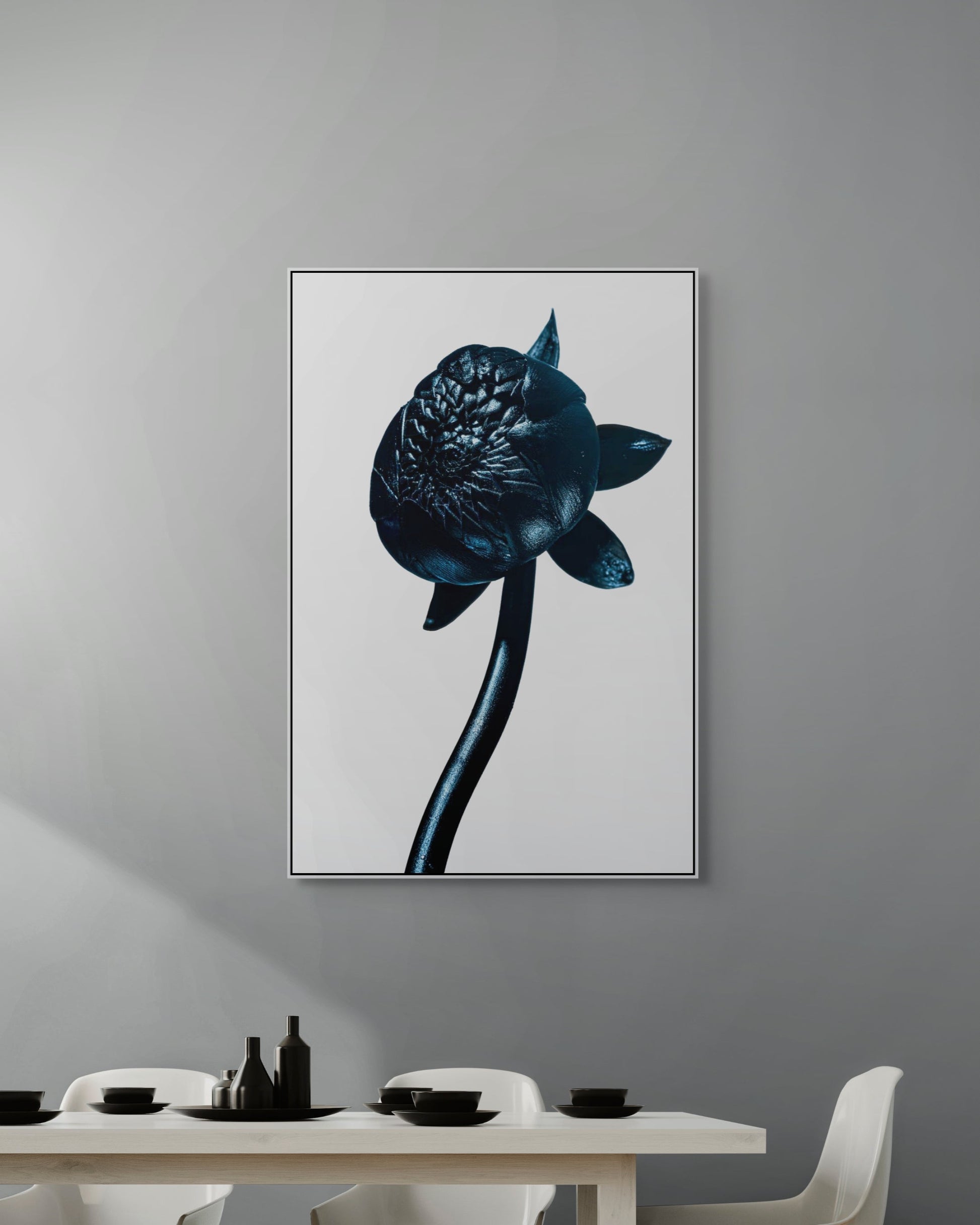Framed artwork of a blue flower on a gray wall above a dining table.