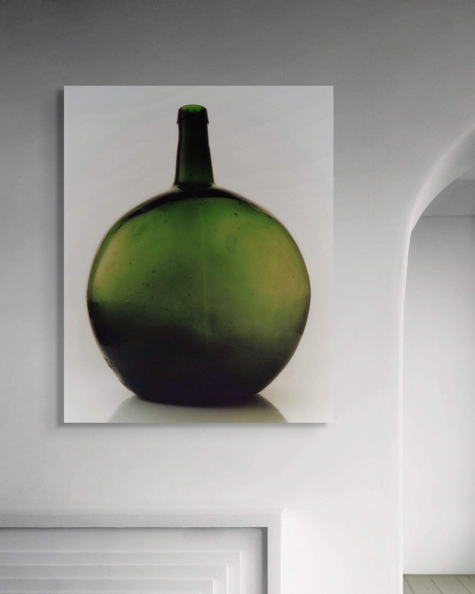 Green ceramic vase on a white wall in a minimalistic room
