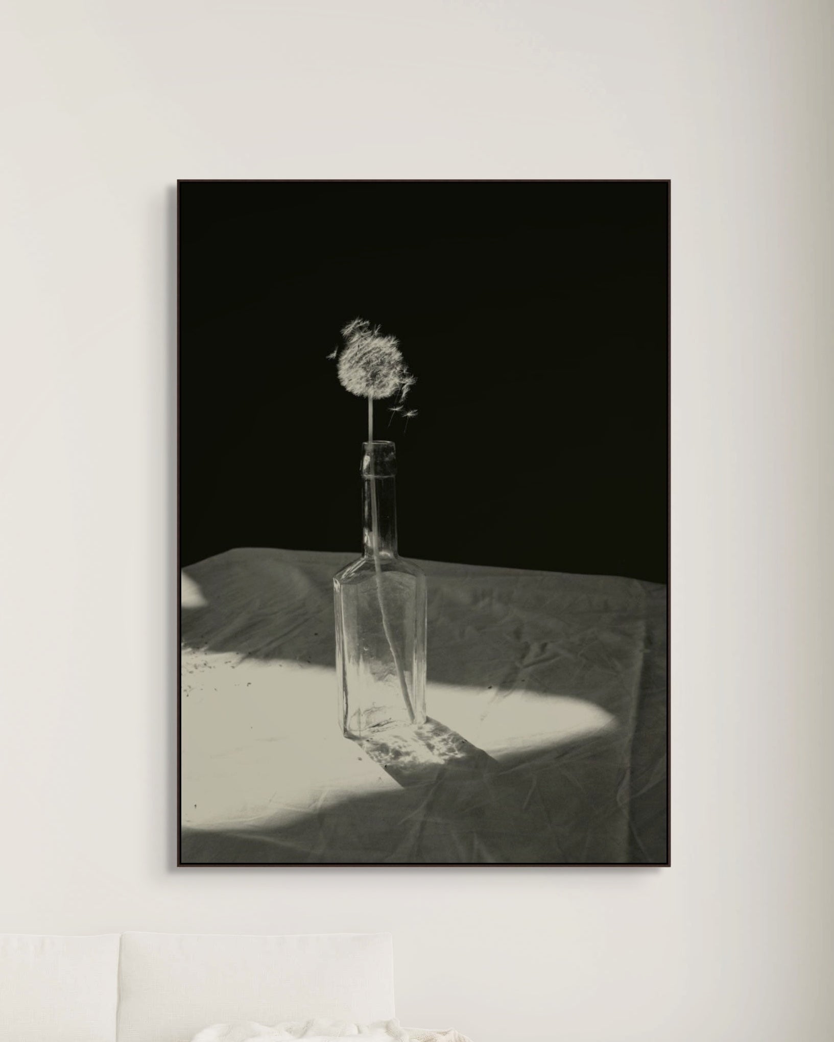 Framed artwork of a dandelion in a bottle on a white surface with a black background