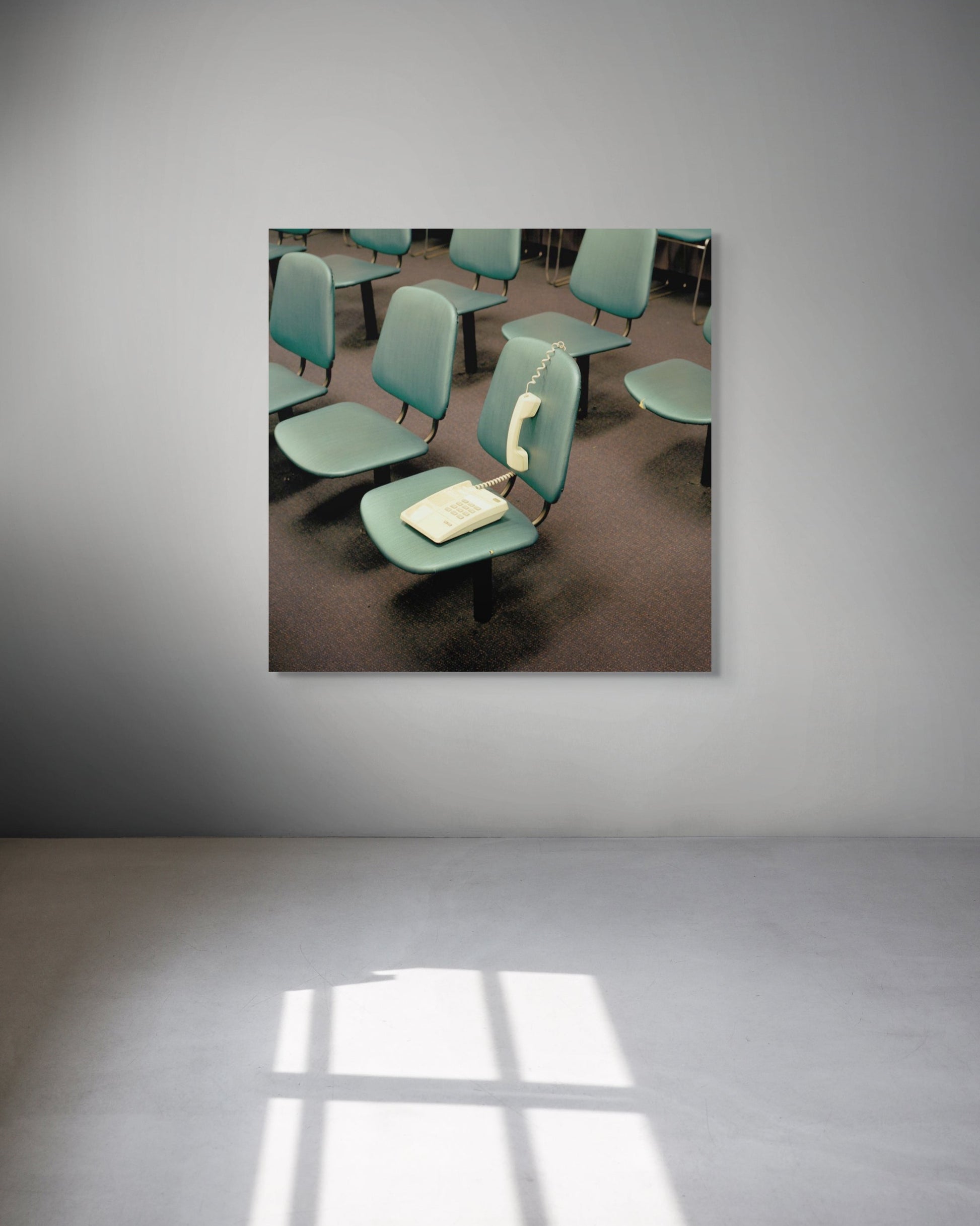 Room with green chairs and a table on a gray wall
