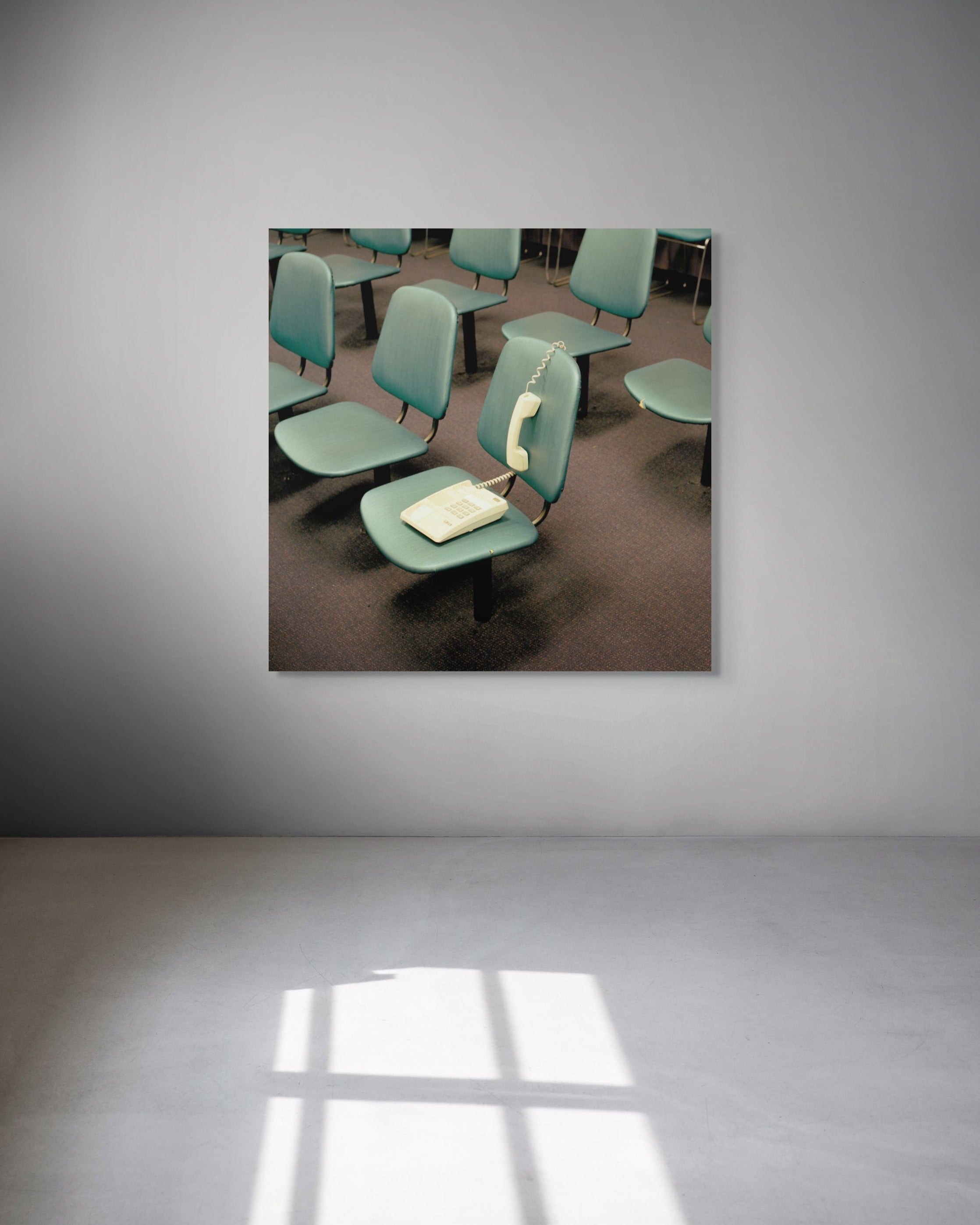 Room with green chairs and a table on a gray wall
