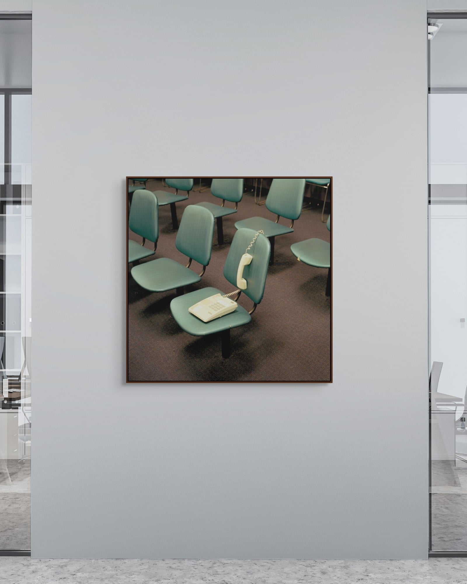 Framed artwork of a room with green chairs and a phone on a gray wall.