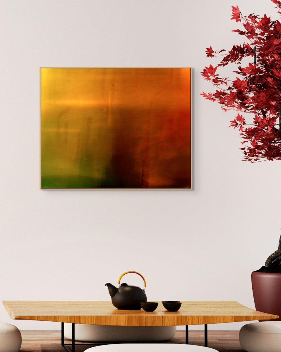Abstract print on a wall above a wooden table with a teapot and bowls.