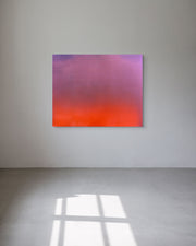 Abstract metal print with pink and orange gradient on a white wall