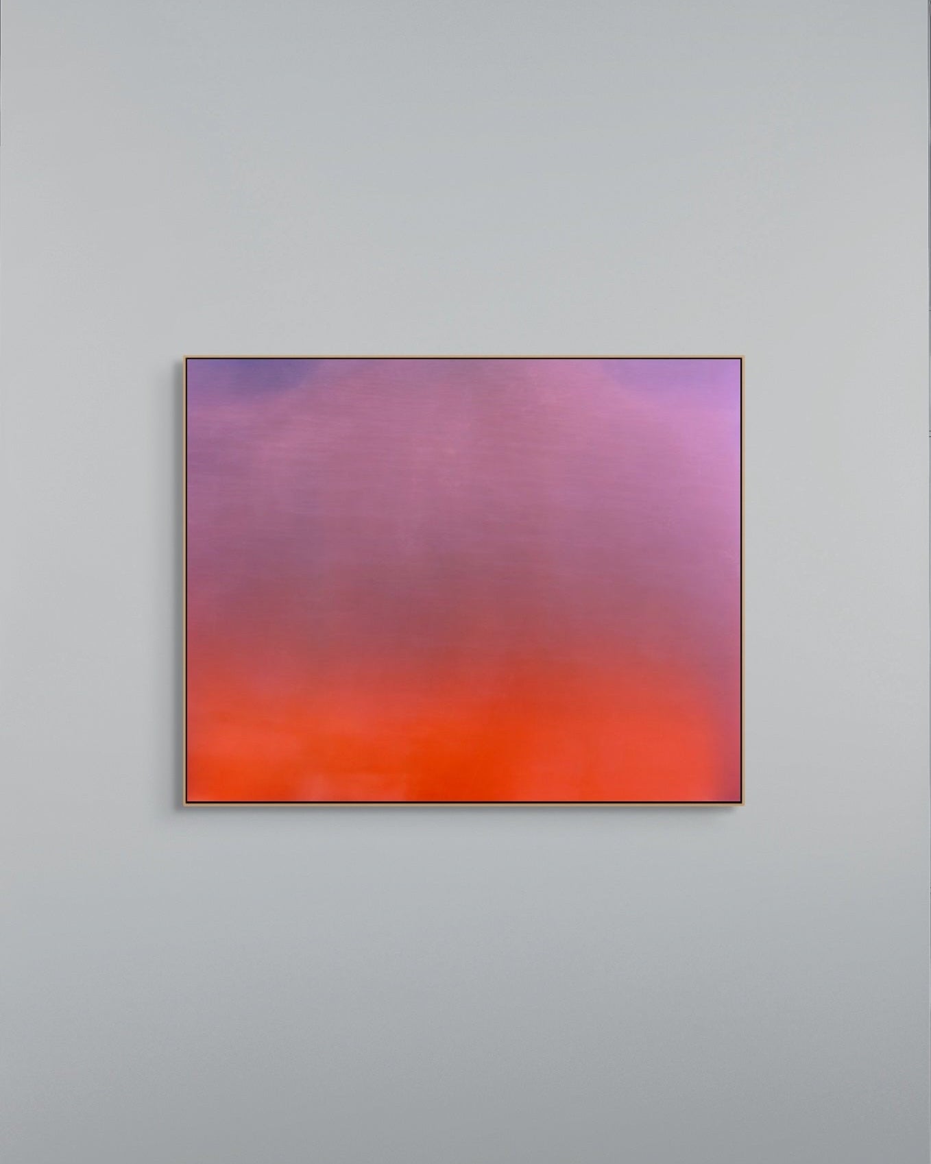 Abstract metal print with gradient of purple and orange on a gray wall