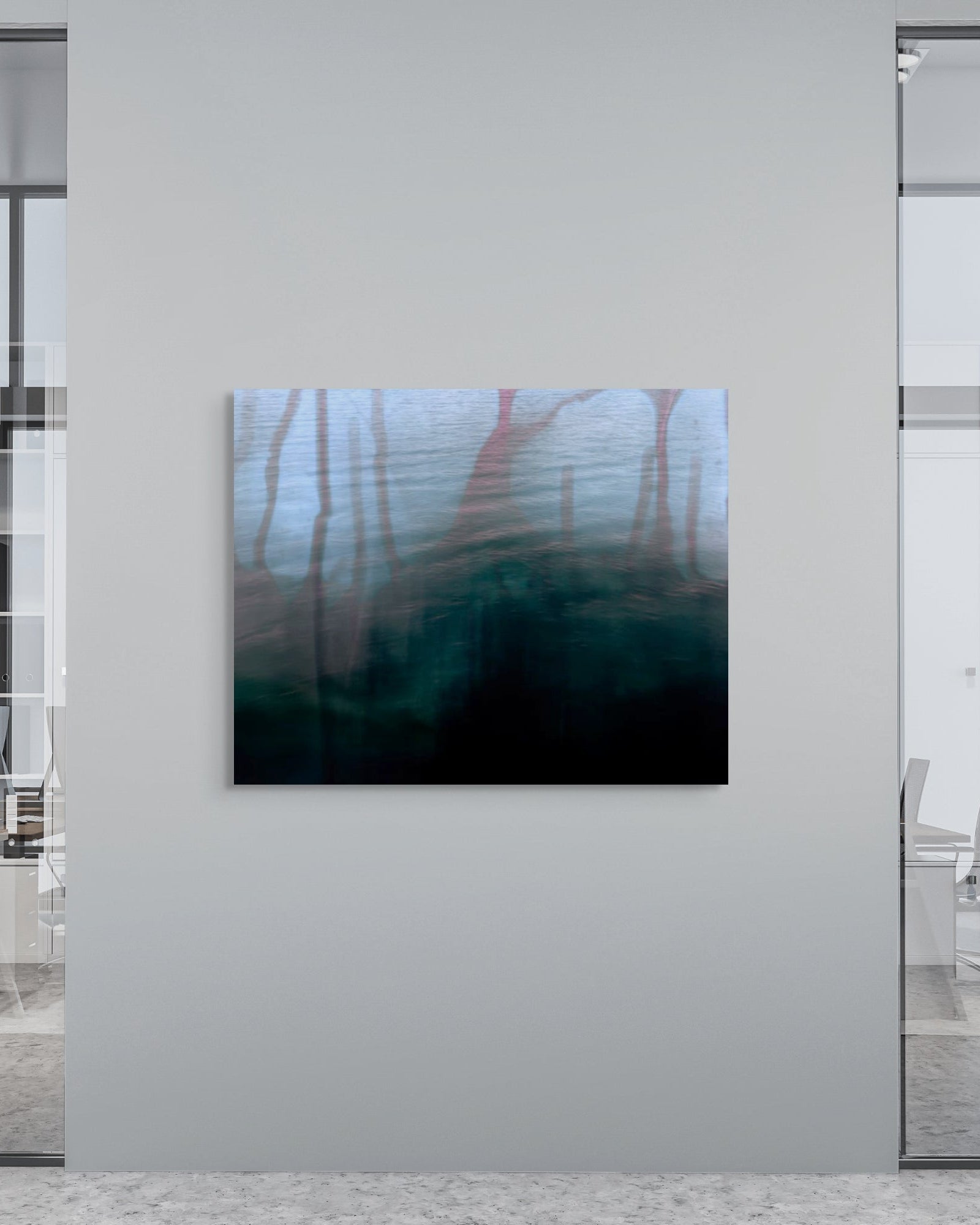 Modern office interior with a large abstract metal print on a wall.