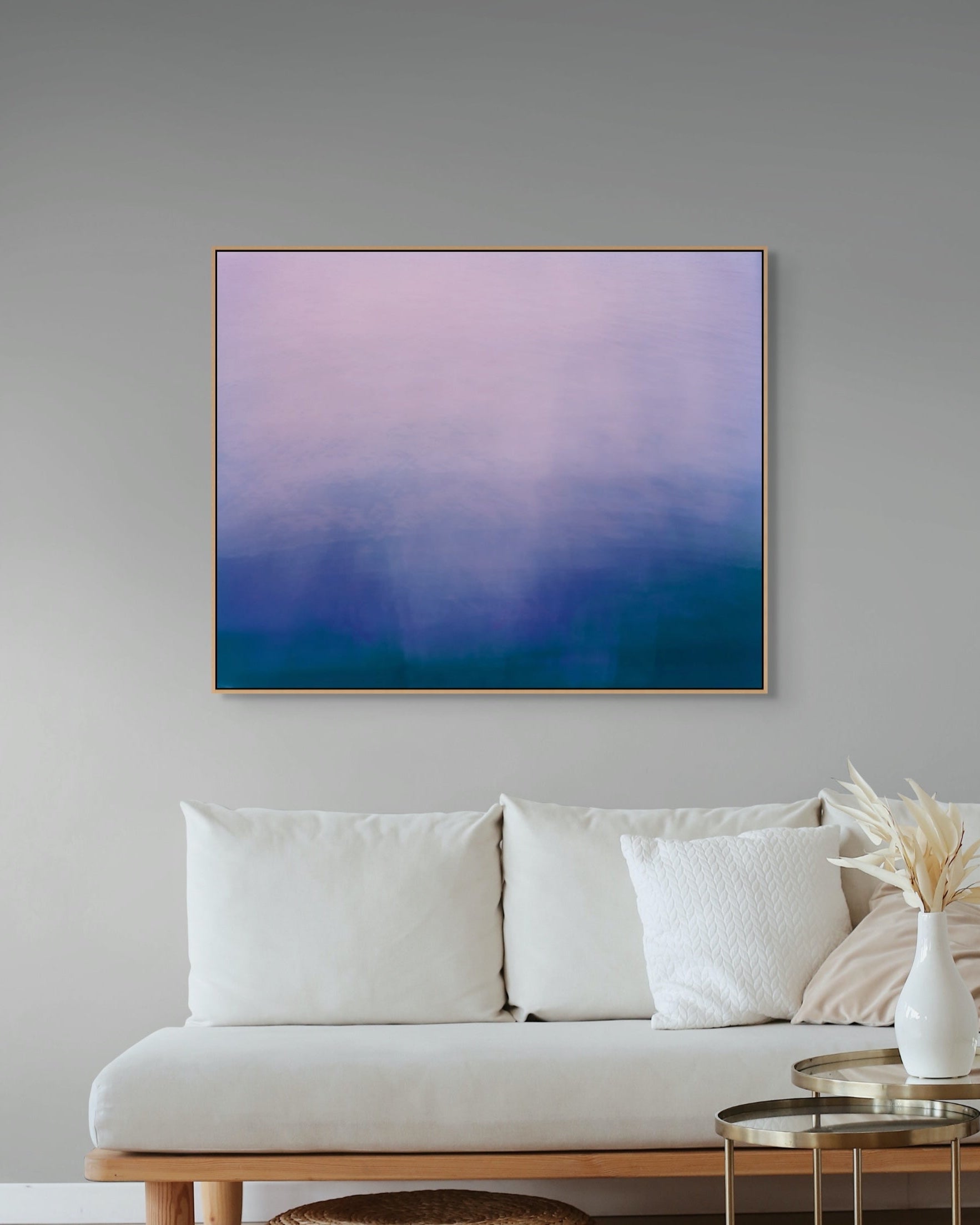 Abstract print on a wall above a sofa in a living room