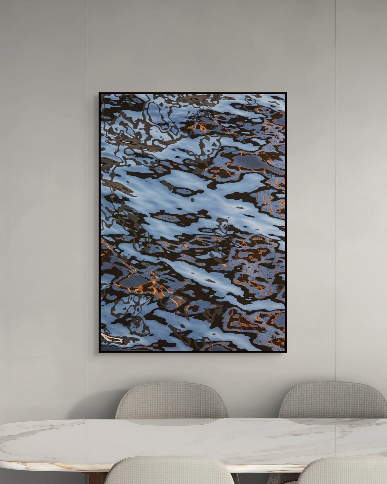 Abstract art piece on a wall above a modern dining table