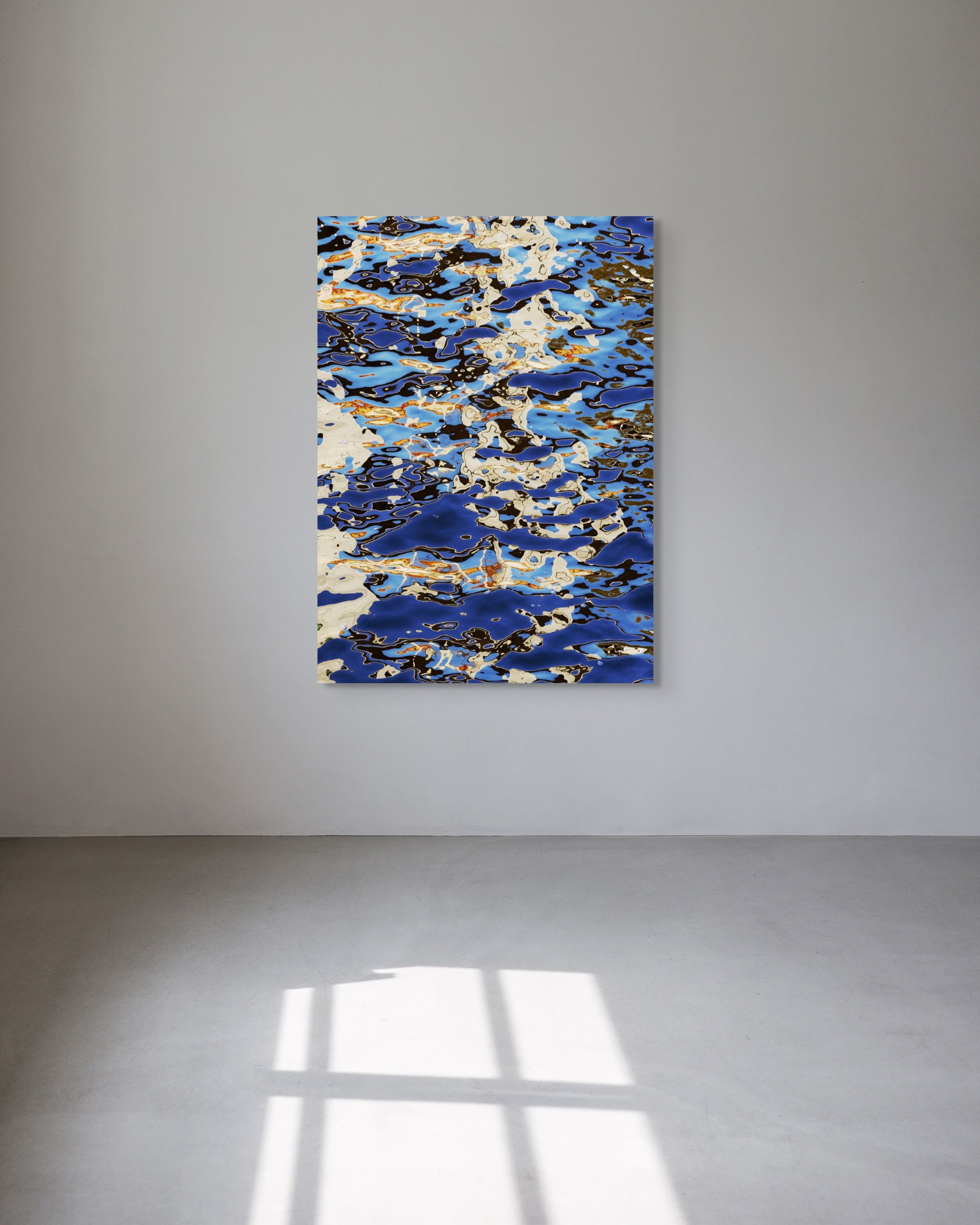 Abstract print with blue and gold tones on a white wall