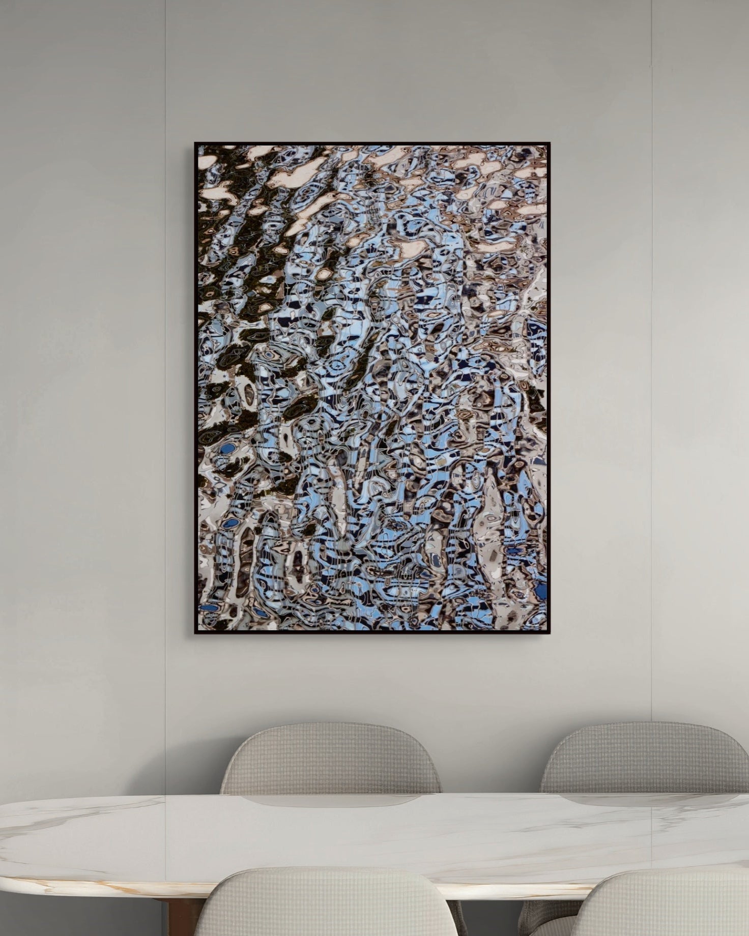 Abstract art piece on a wall above a dining table with chairs.