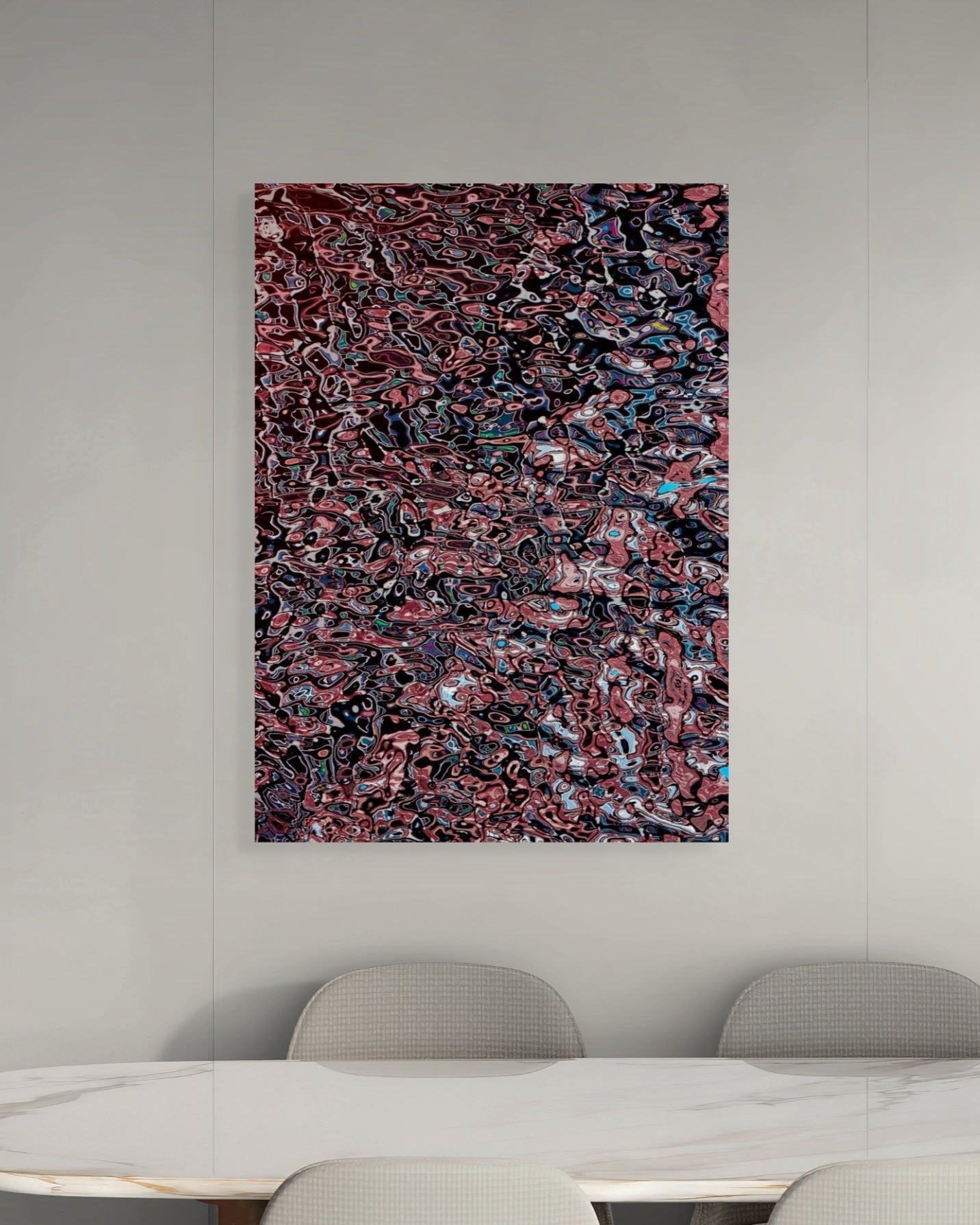 Abstract art piece on a wall above a dining table with chairs.