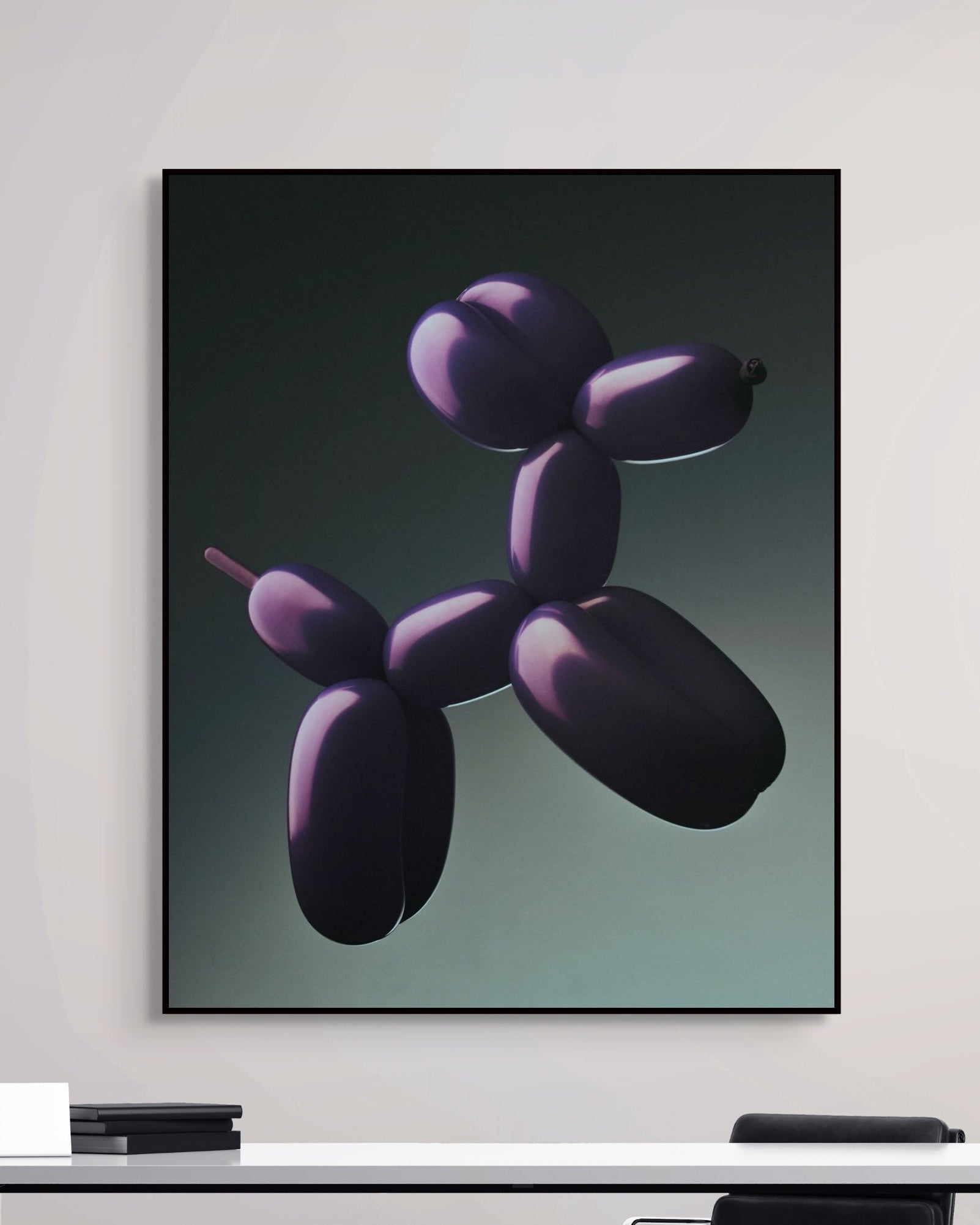 Framed artwork of a balloon animal on a wall above a desk.