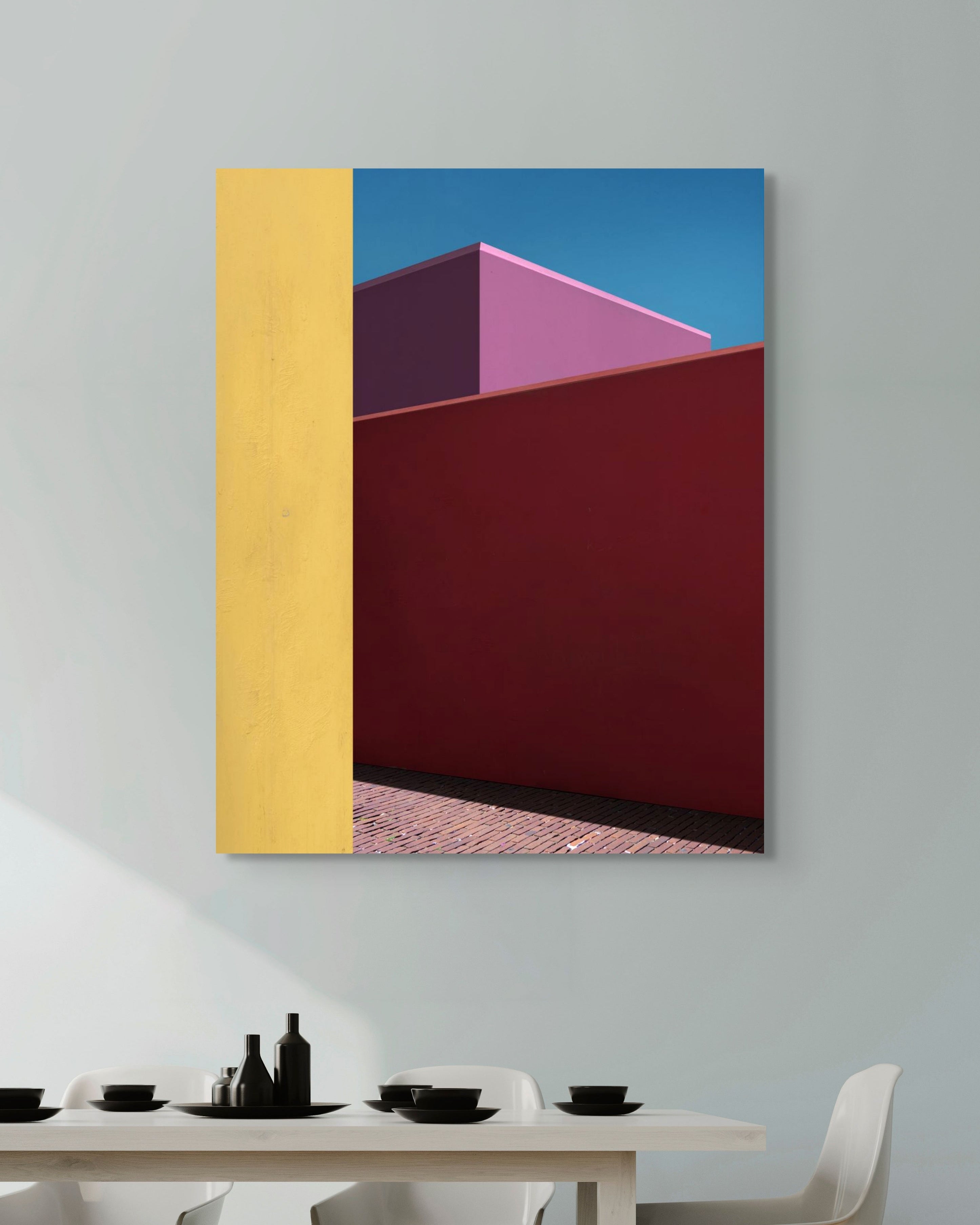 Abstract art piece with geometric shapes on a wall above a dining table.