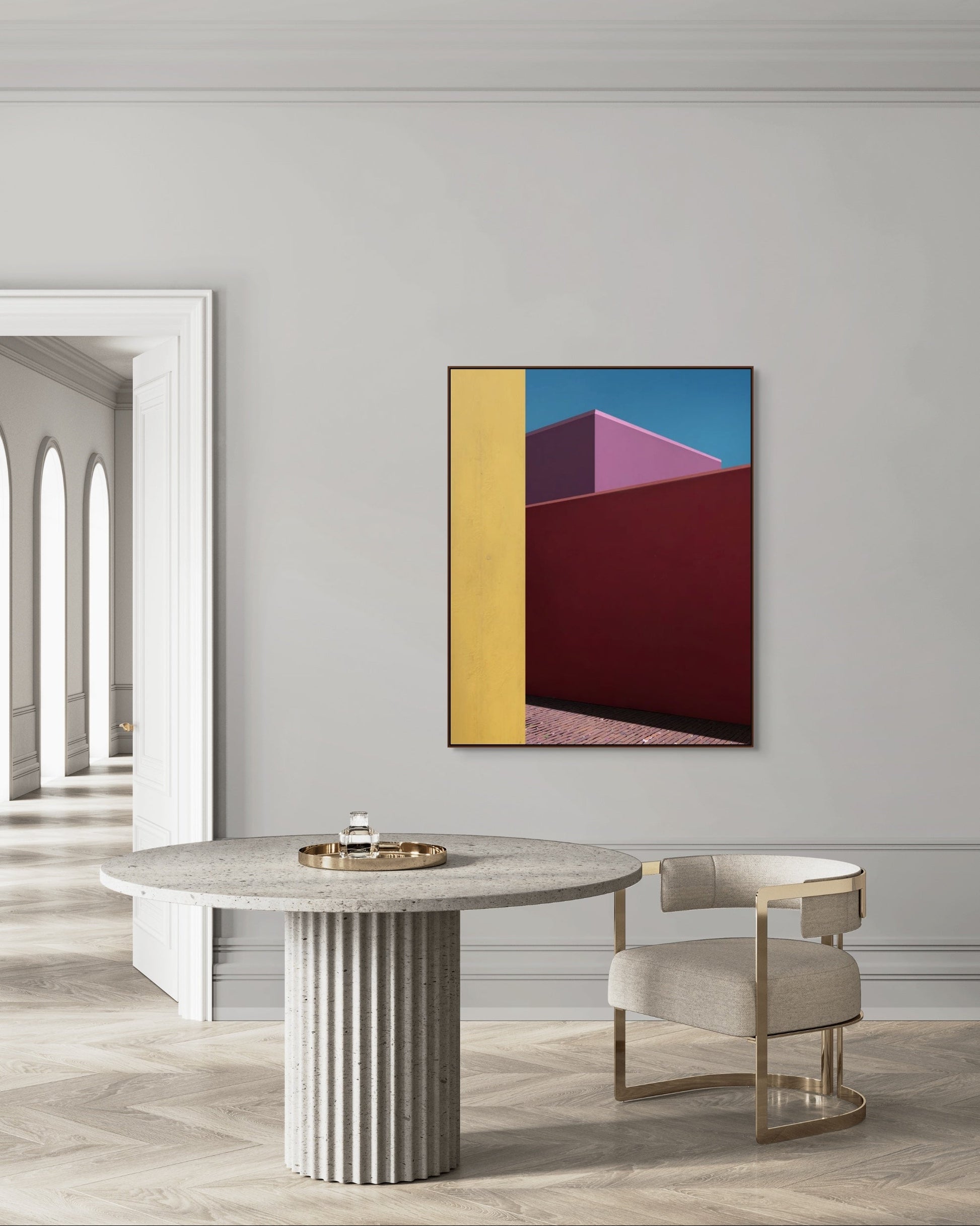 Modern interior with a round marble table and chair, featuring a colorful abstract print on the wall.