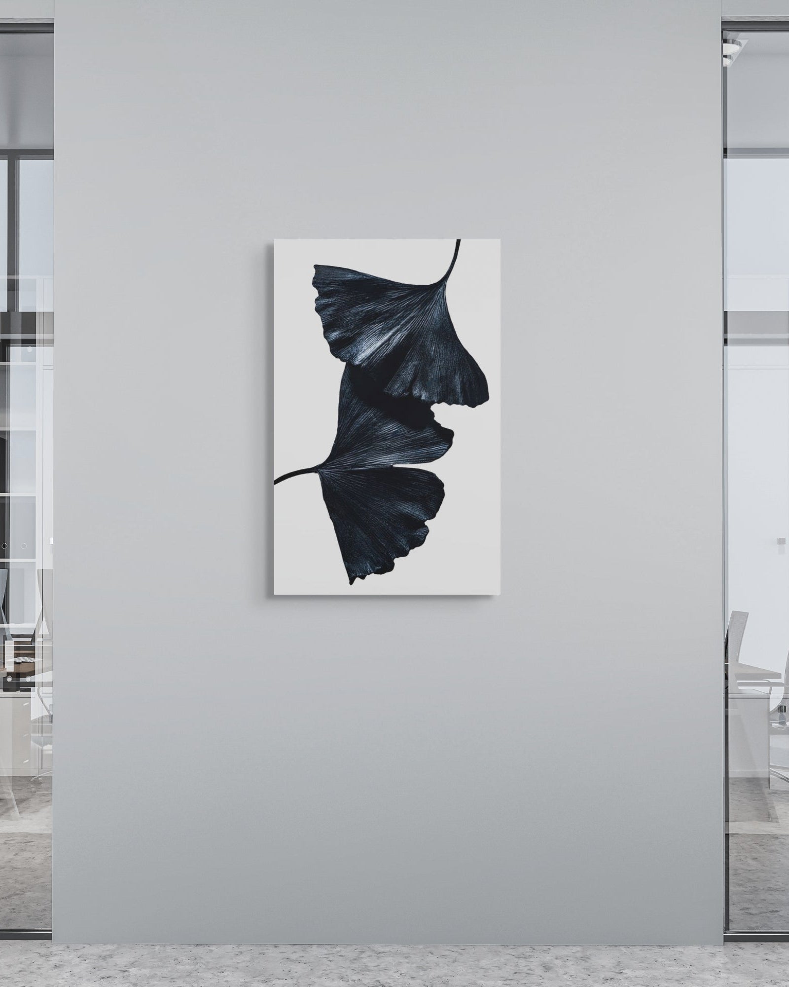 Modern office interior with a black and white abstract metal print on a gray wall.